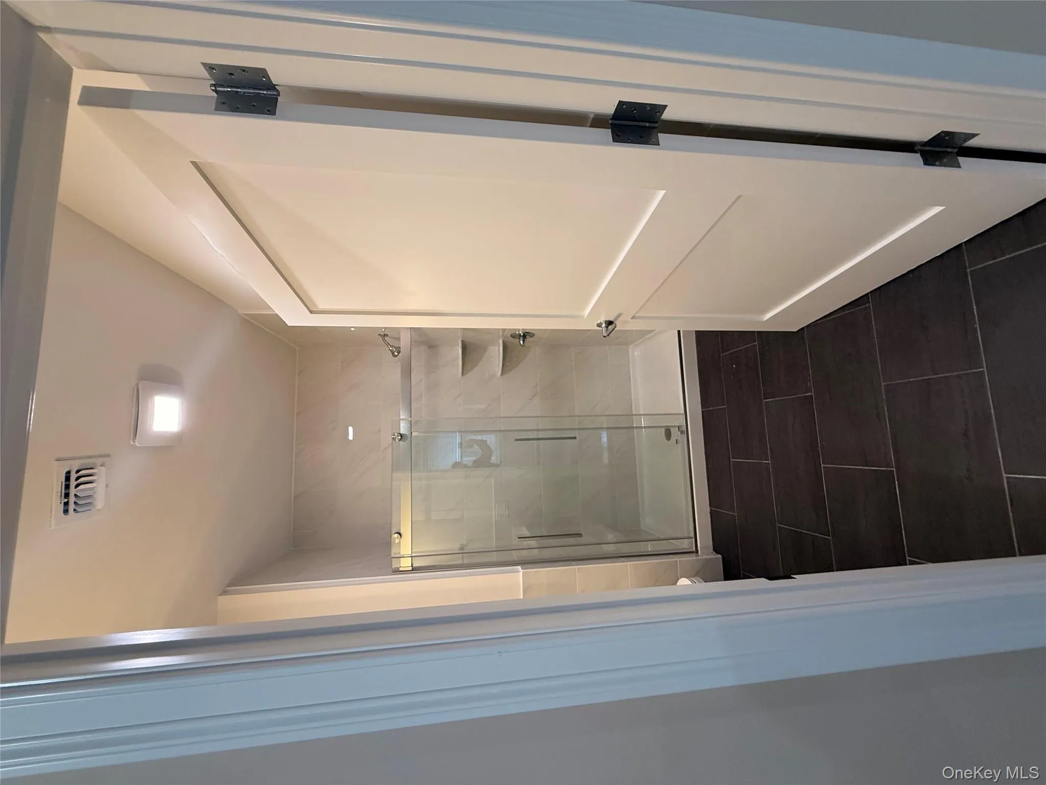 Full bathroom featuring a shower stall and dark tile patterned flooring Full bathroom featuring a shower stall and dark tile patterned flooring