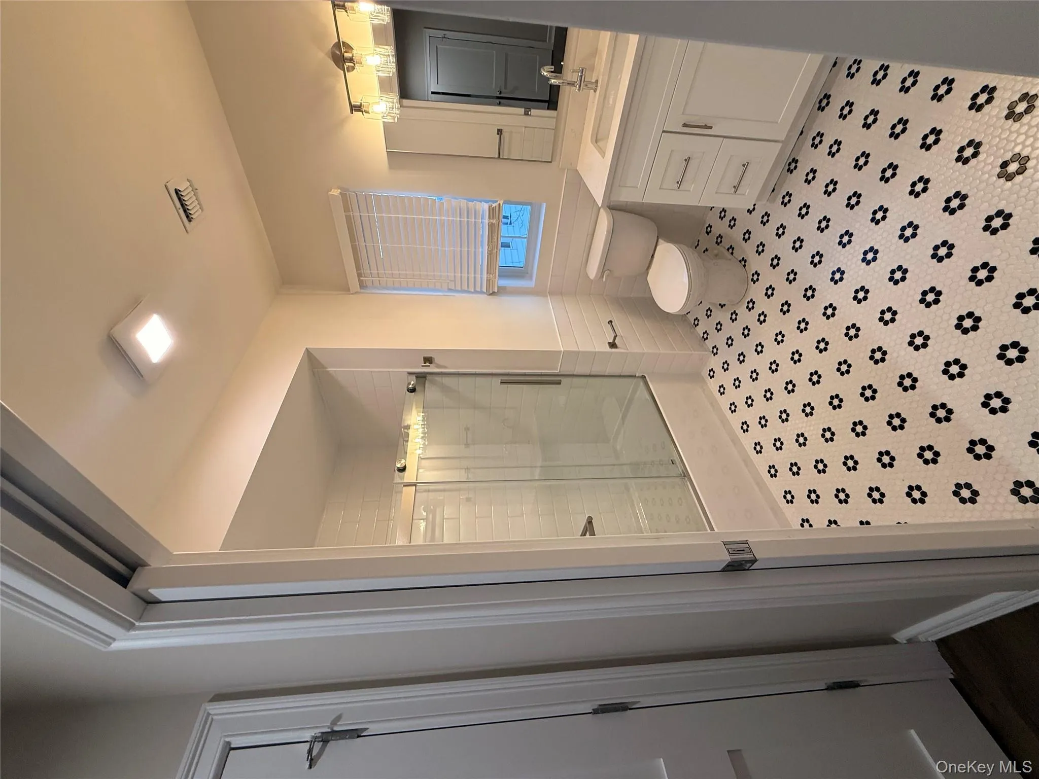 Full bathroom featuring a stall shower, vanity, a wainscoted wall, and tile walls Full bathroom featuring a stall shower, vanity, a wainscoted wall, and tile walls