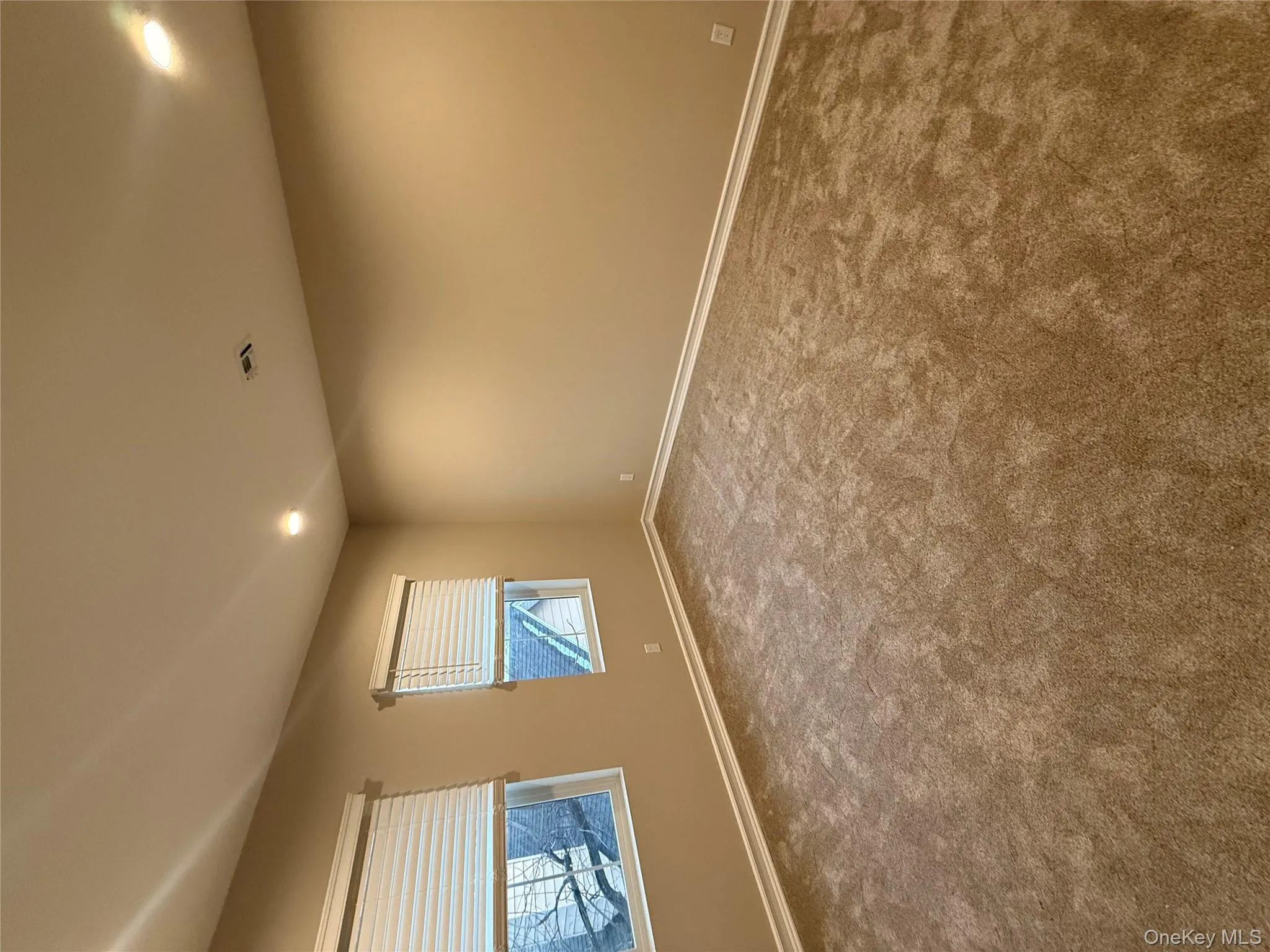 Empty room with recessed lighting and dark carpet Empty room with recessed lighting and dark carpet