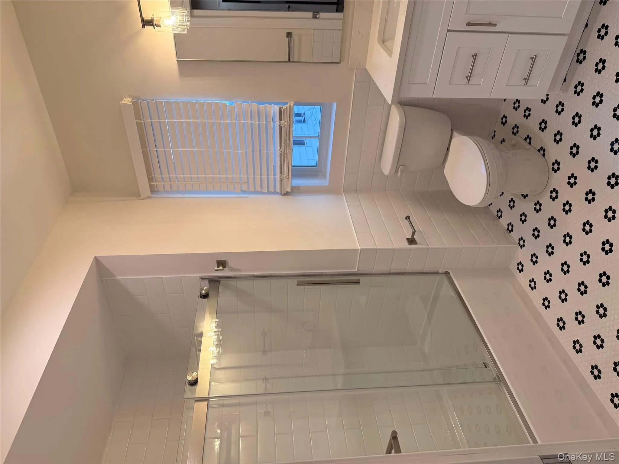 Full bath with a stall shower, vanity, tile walls, and wainscoting Full bath with a stall shower, vanity, tile walls, and wainscoting