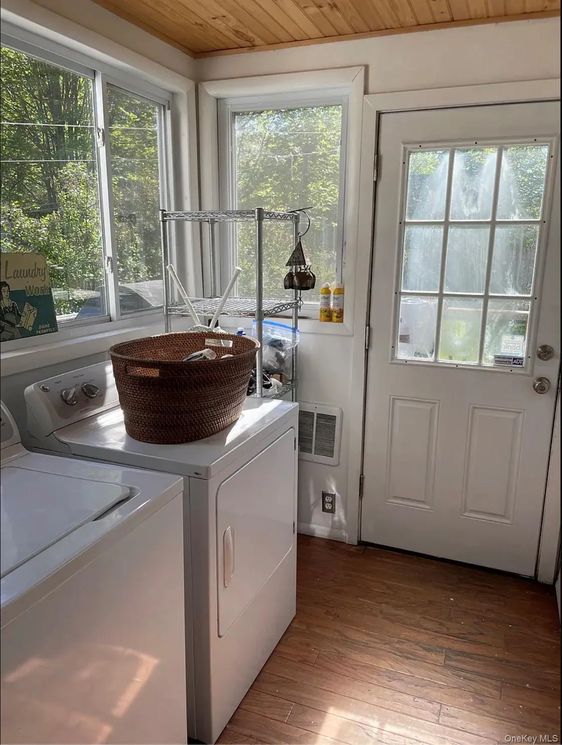 Laundry area featuring light wood-style floors, washing machine and clothes dryer, wood ceiling, and heating unit Laundry area featuring light wood-style floors, washing machine and clothes dryer, wood ceiling, and heating unit