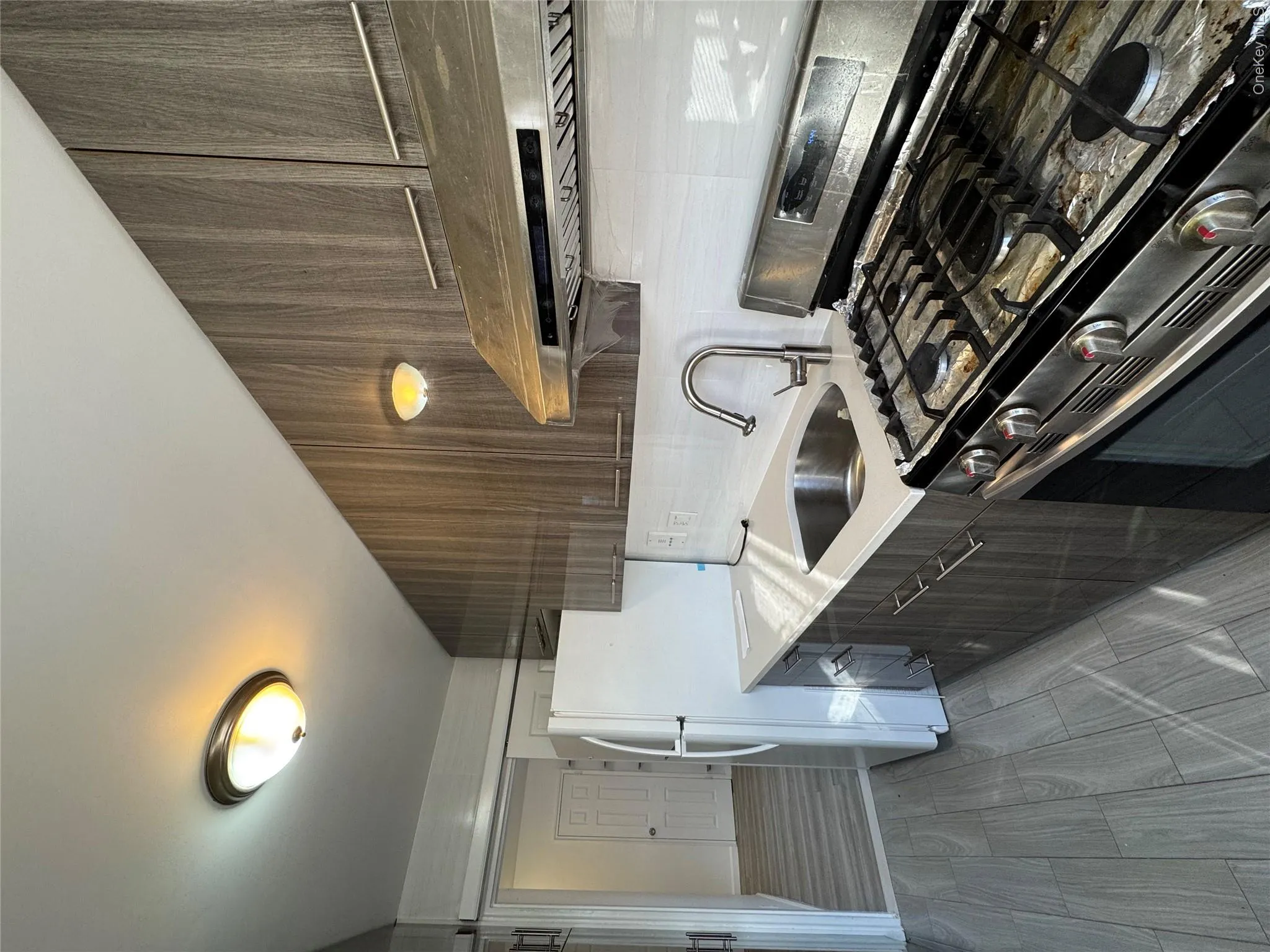 Kitchen with white stove, modern cabinets, range hood, decorative backsplash, and light stone countertops Kitchen with white stove, modern cabinets, range hood, decorative backsplash, and light stone countertops