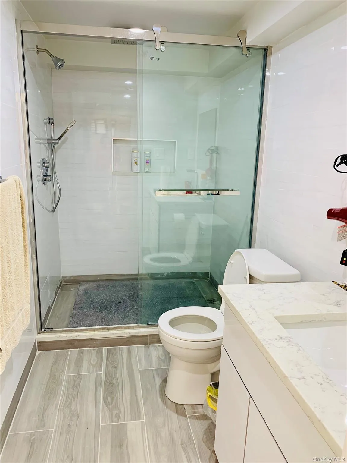 Bathroom featuring wood tiled floors, a stall shower, and vanity Bathroom featuring wood tiled floors, a stall shower, and vanity