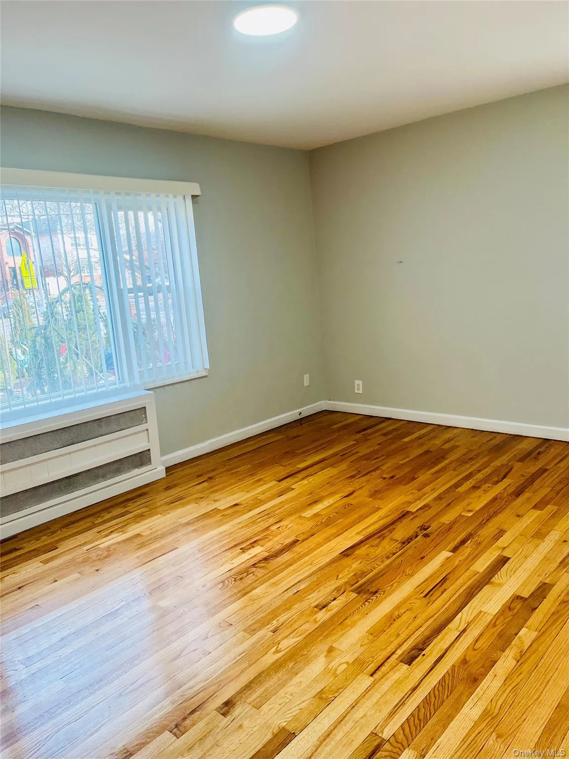 Empty room with light wood finished floors and baseboards Empty room with light wood finished floors and baseboards