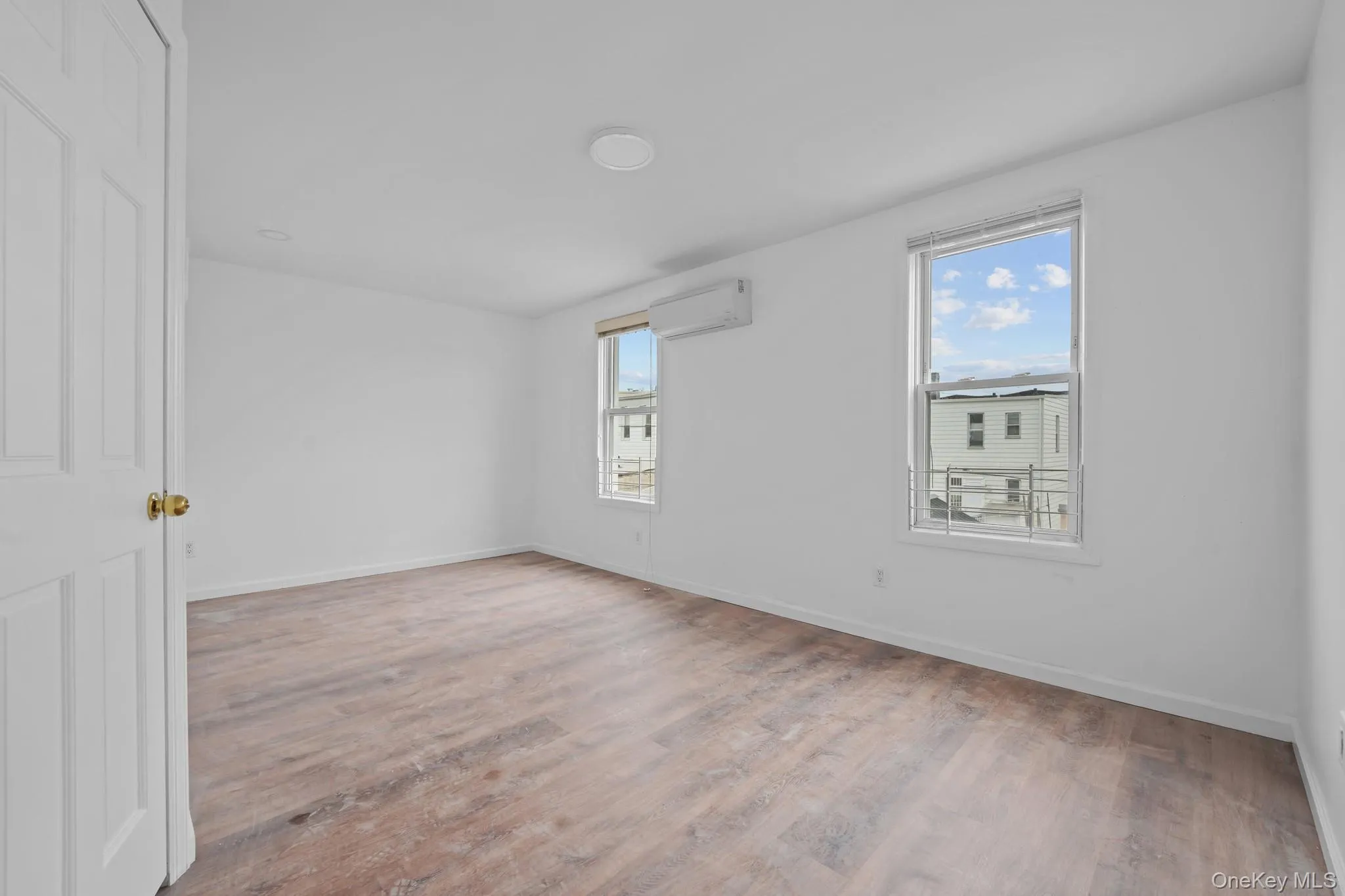 Unfurnished room featuring light wood-type flooring and a wall unit AC Unfurnished room featuring light wood-type flooring and a wall unit AC