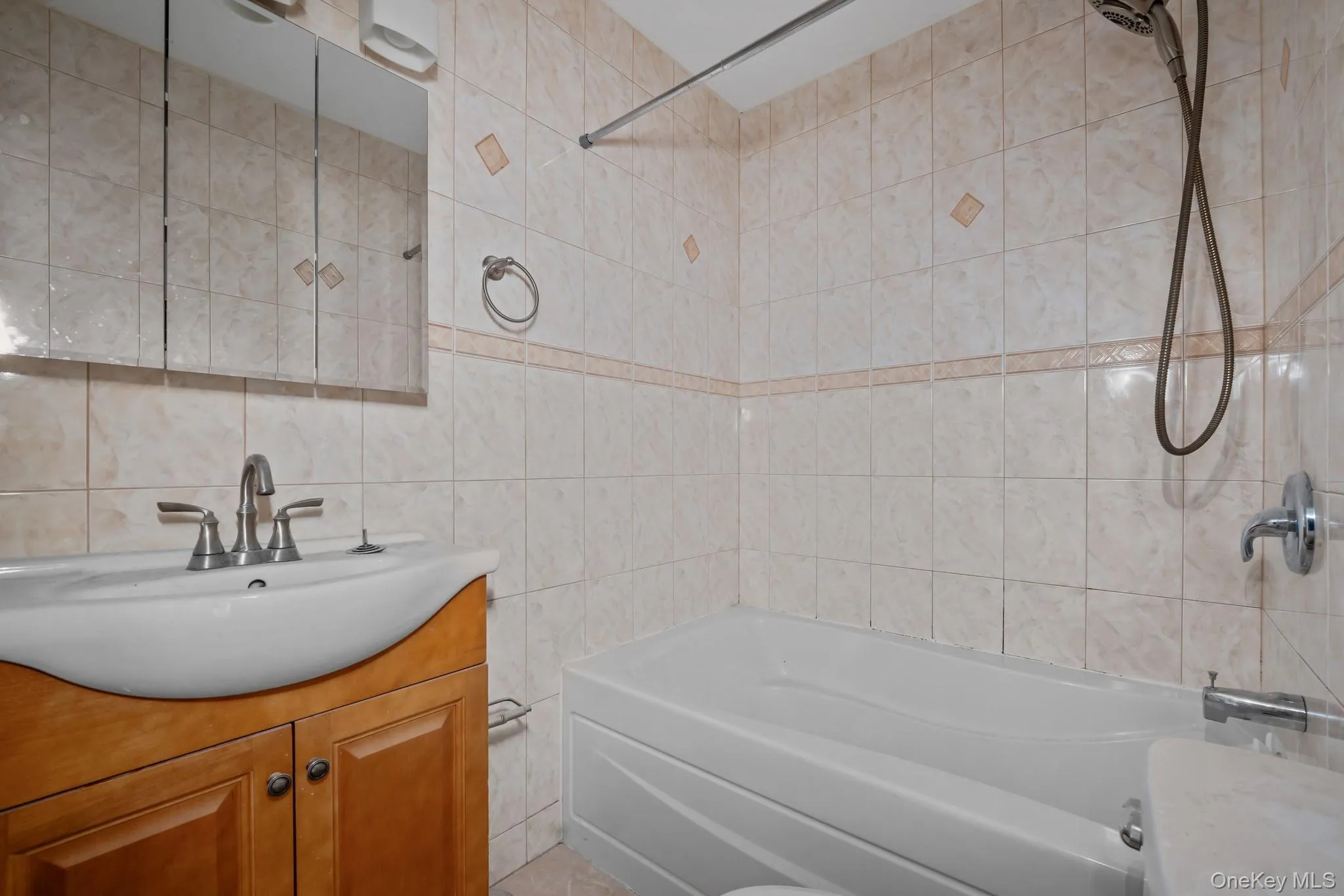 Full bath with shower / bathtub combination, vanity, and tile walls Full bath with shower / bathtub combination, vanity, and tile walls