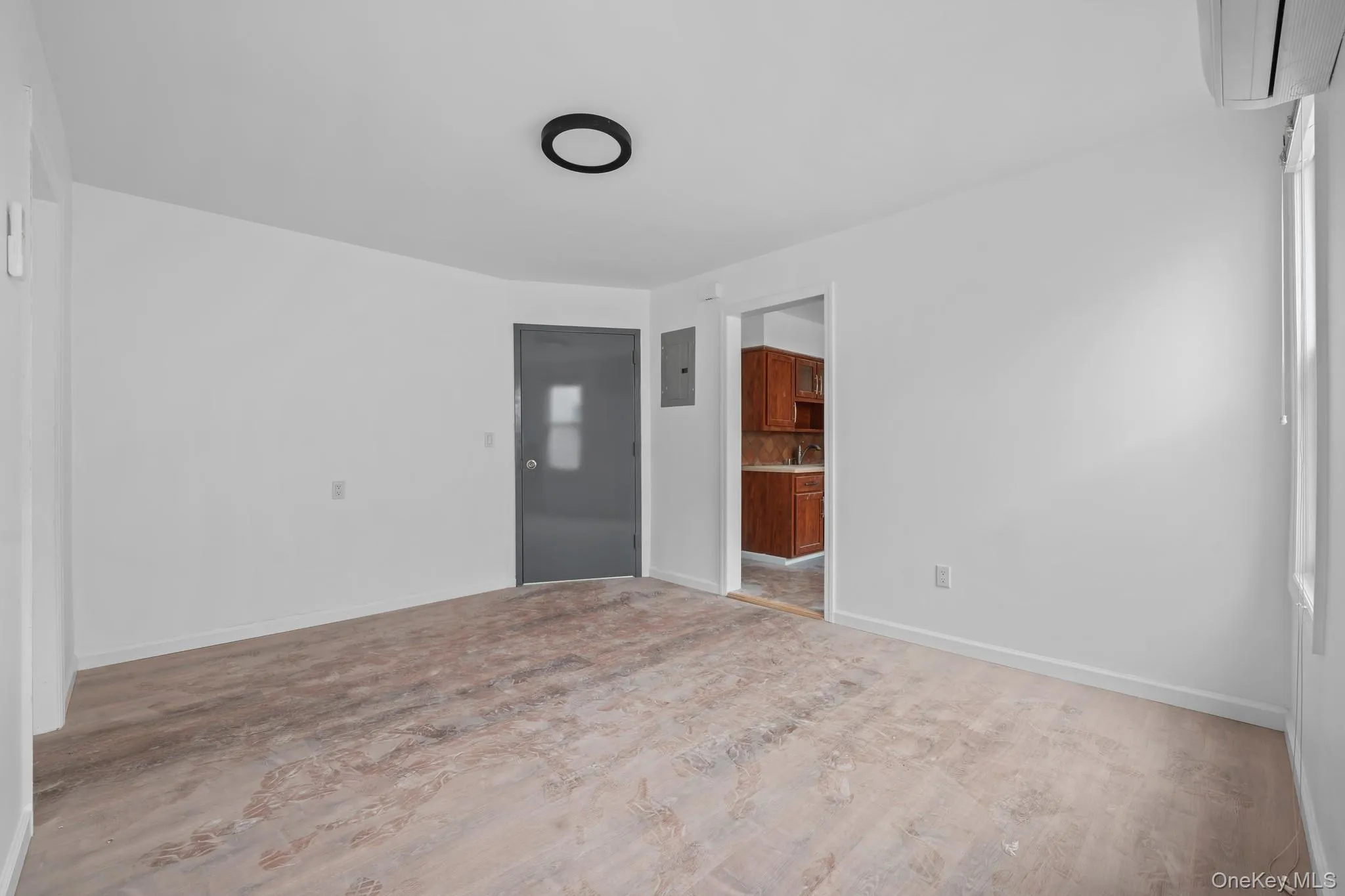 Unfurnished room featuring an AC wall unit and electric panel Unfurnished room featuring an AC wall unit and electric panel