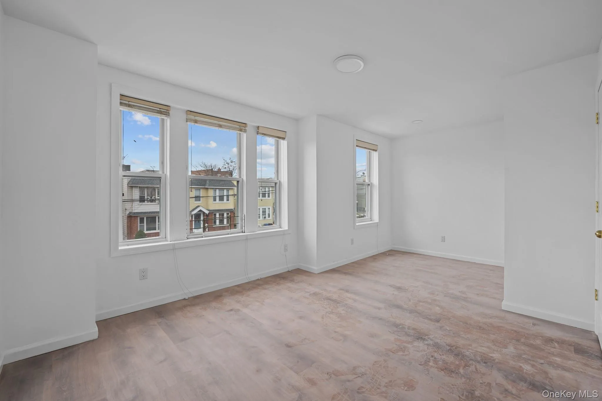 Empty room with light wood finished floors and baseboards Empty room with light wood finished floors and baseboards