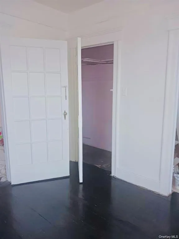 Unfurnished bedroom with dark wood finished floors and a closet Unfurnished bedroom with dark wood finished floors and a closet