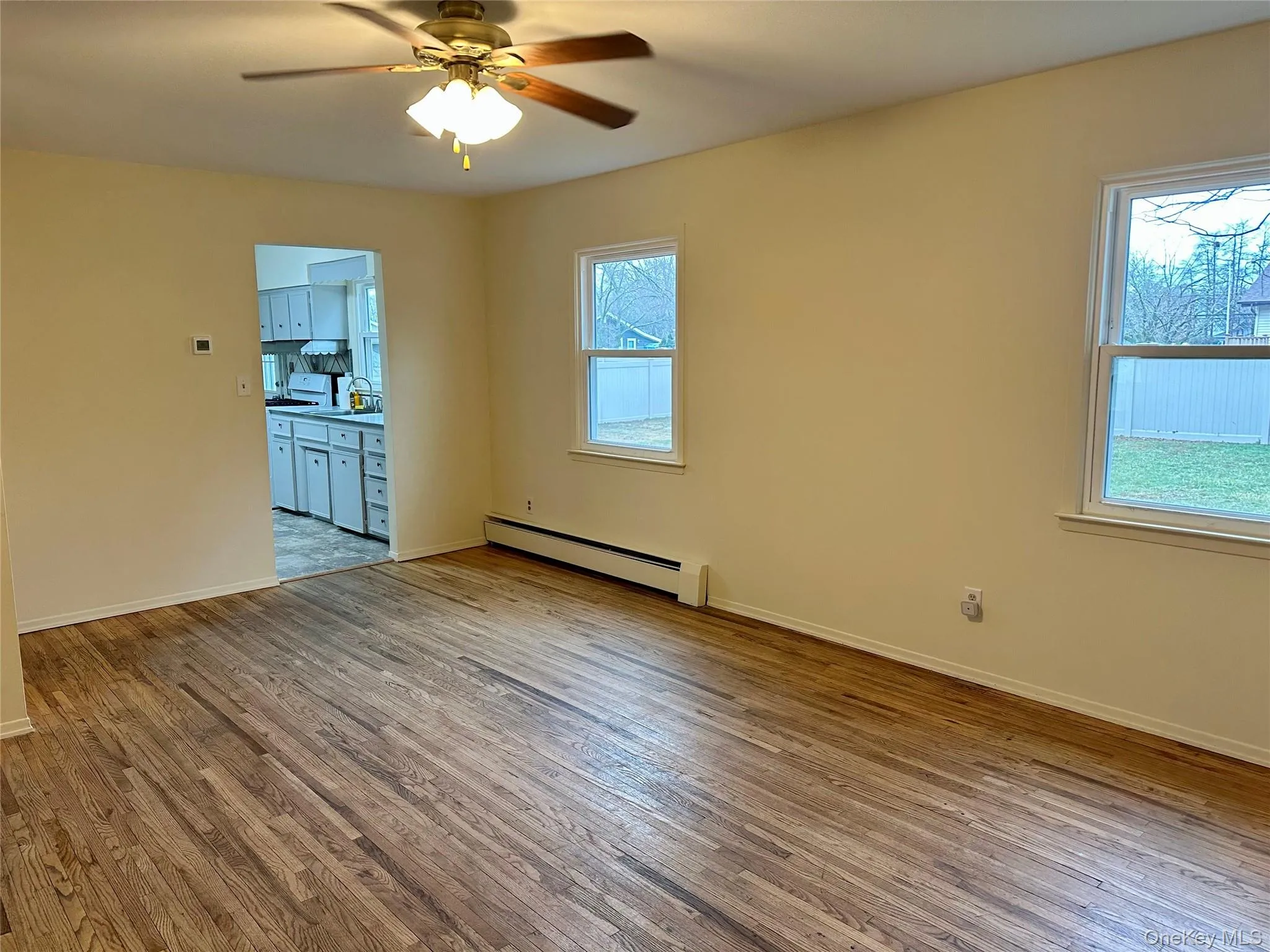Spare room featuring light wood-type flooring, baseboard heating, and ceiling fan Spare room featuring light wood-type flooring, baseboard heating, and ceiling fan