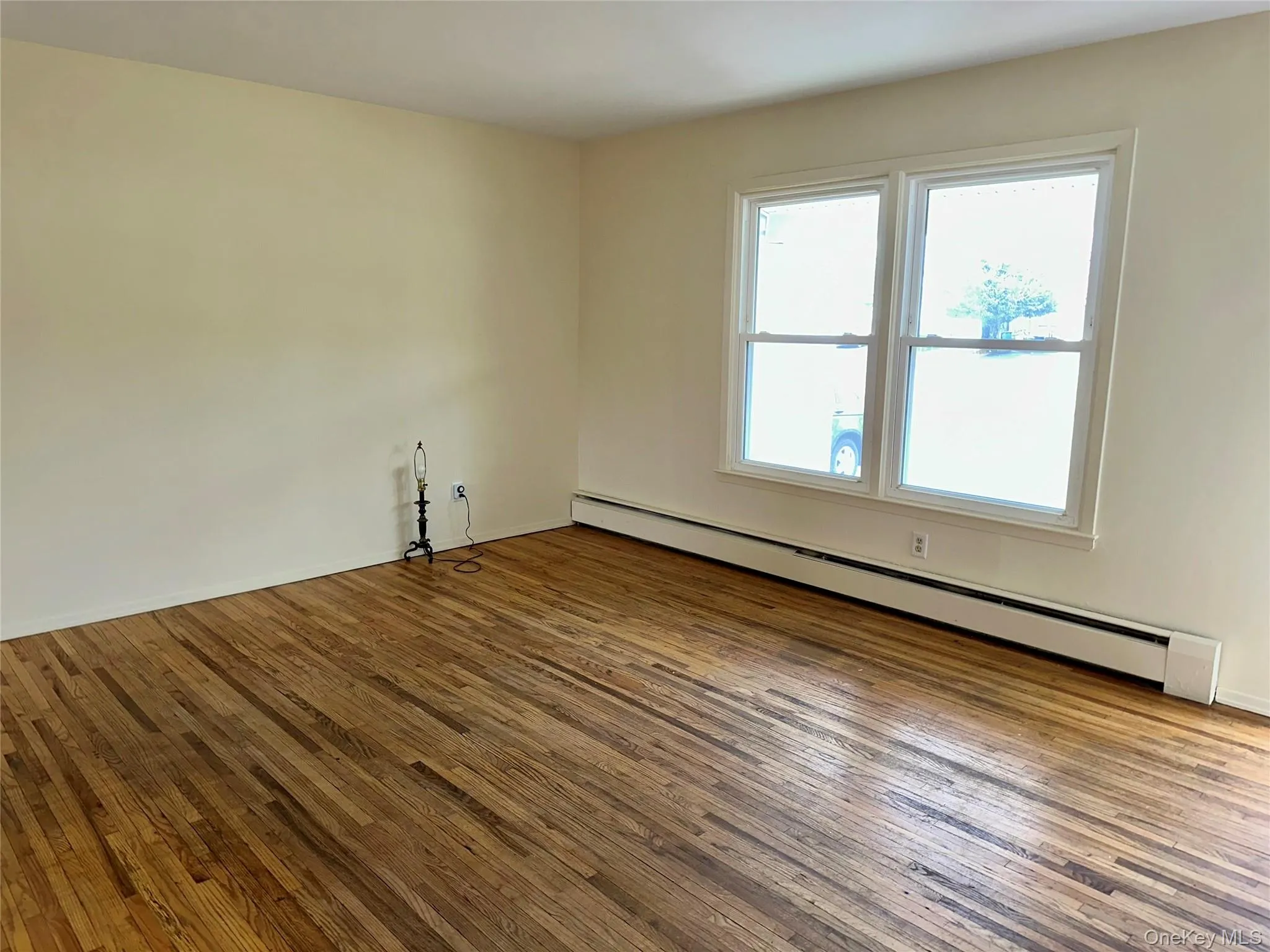 Spare room featuring a baseboard heating unit and hardwood / wood-style flooring Spare room featuring a baseboard heating unit and hardwood / wood-style flooring