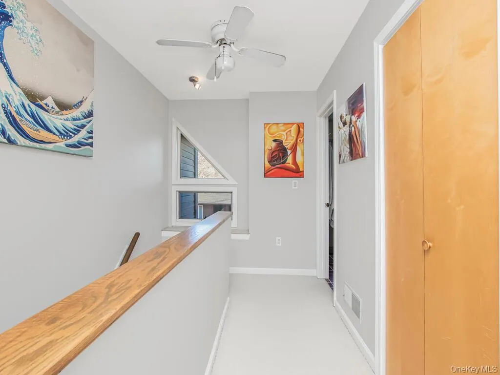 Hall featuring an upstairs landing and light colored carpet Hall featuring an upstairs landing and light colored carpet