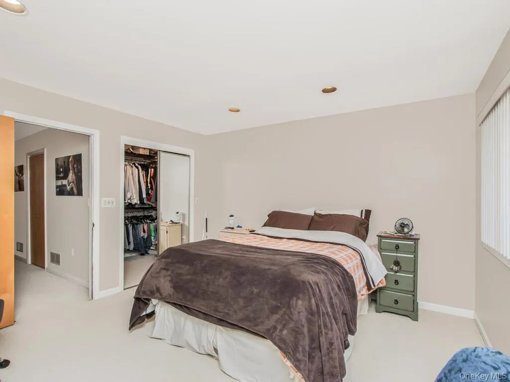 Bedroom with light colored carpet, a walk in closet, and recessed lighting Bedroom with light colored carpet, a walk in closet, and recessed lighting