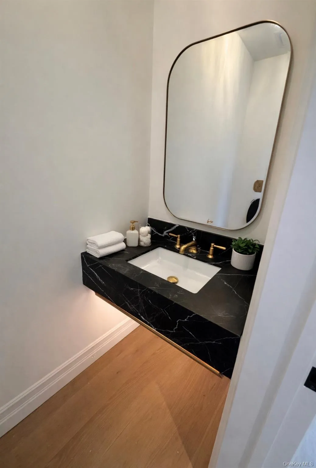 Half bathroom with vanity and wood finished floors Half bathroom with vanity and wood finished floors