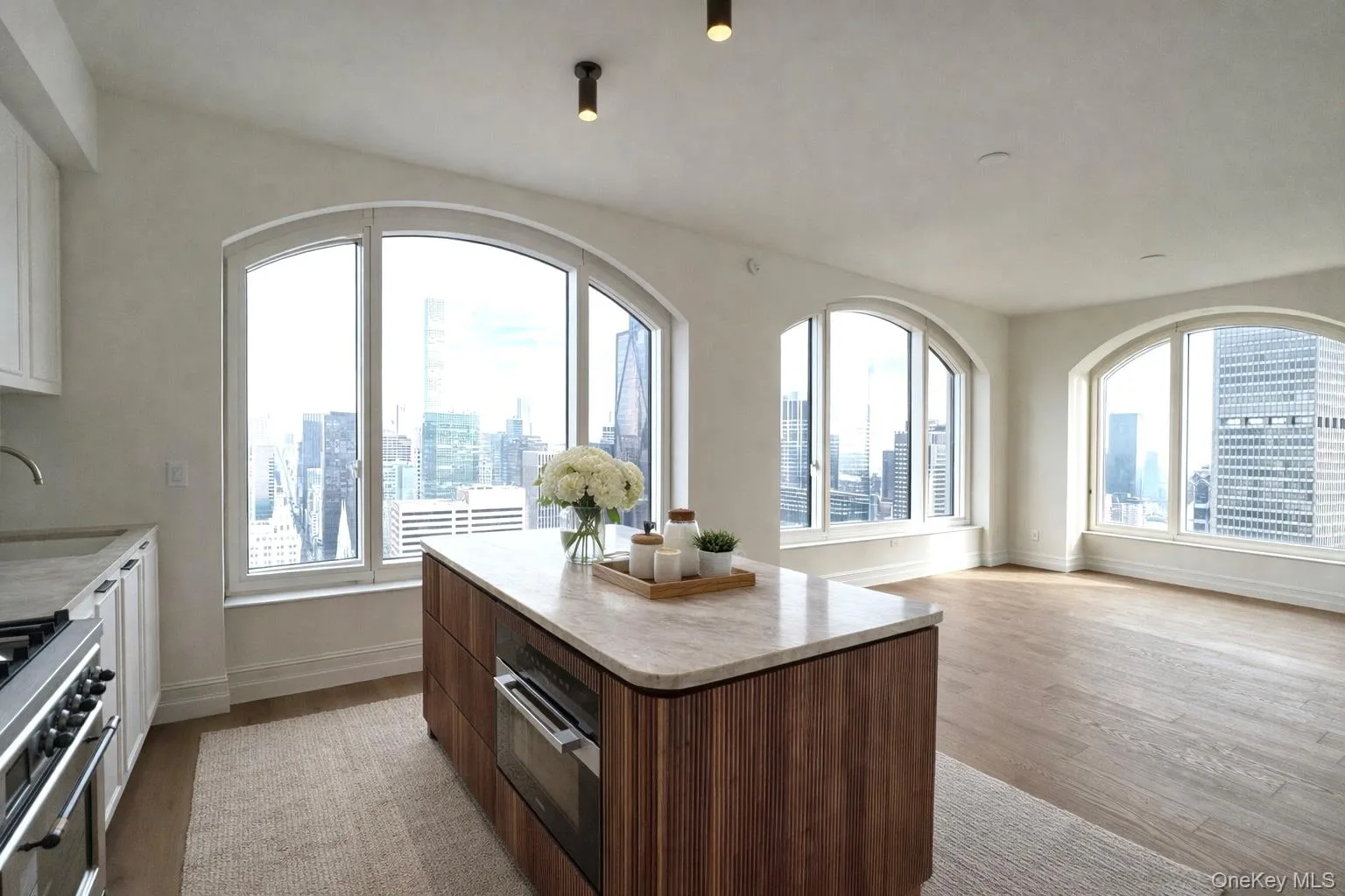 Kitchen with white cabinets, a view of skyline, stainless steel gas stove, open floor plan, and a center island Kitchen with white cabinets, a view of skyline, stainless steel gas stove, open floor plan, and a center island