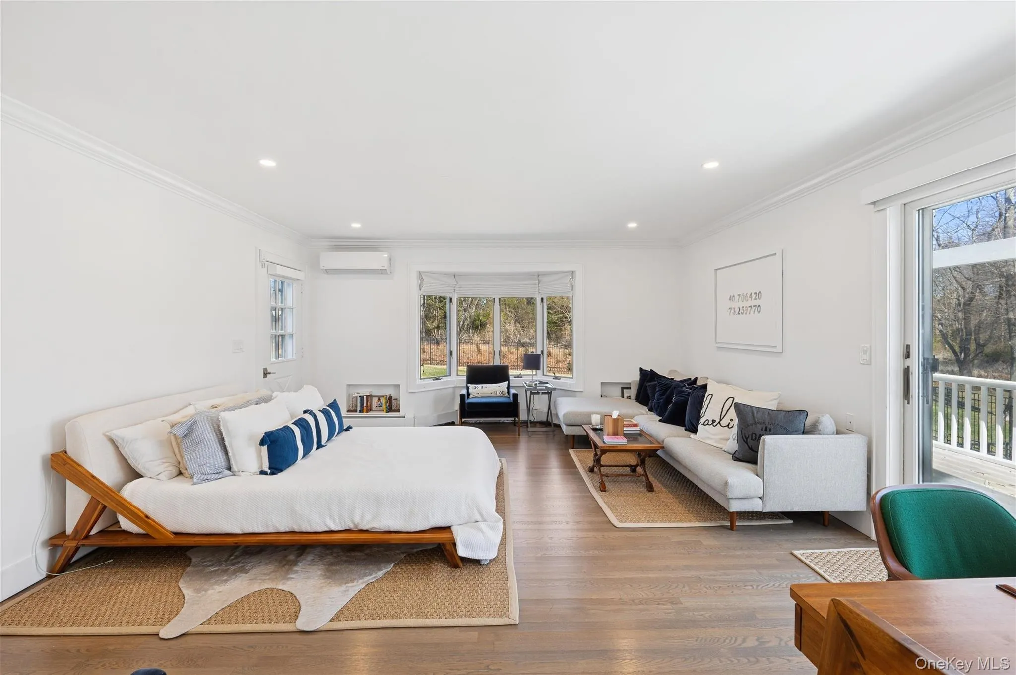 Bedroom with access to outside, wood finished floors, multiple windows, and an AC wall unit Bedroom with access to outside, wood finished floors, multiple windows, and an AC wall unit