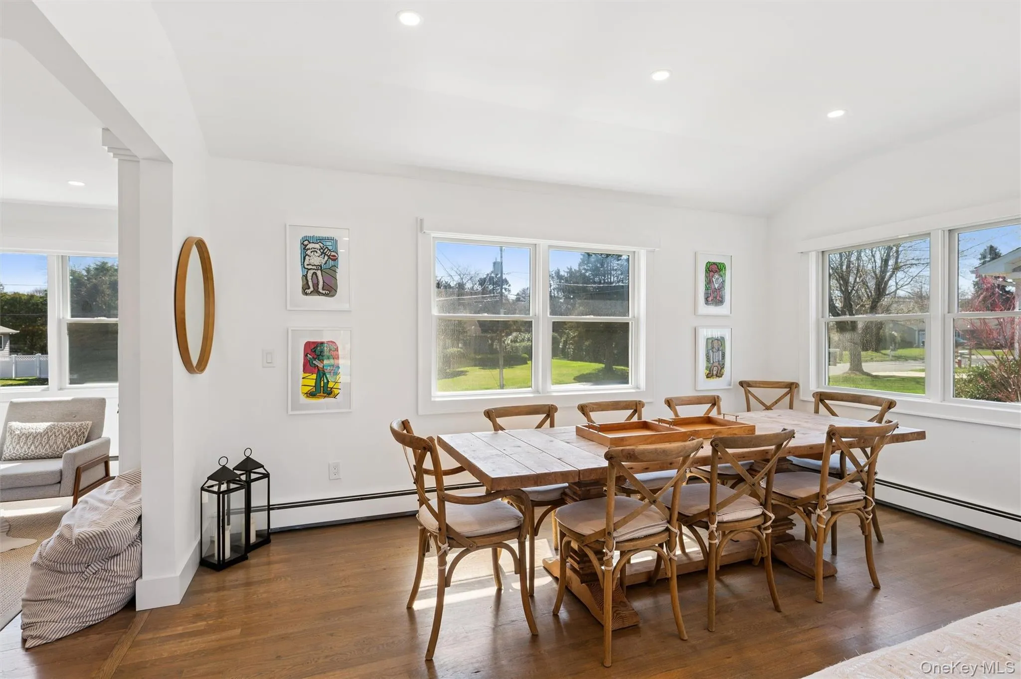 Dining room with dark wood-style floors, a baseboard radiator, and a healthy amount of sunlight Dining room with dark wood-style floors, a baseboard radiator, and a healthy amount of sunlight