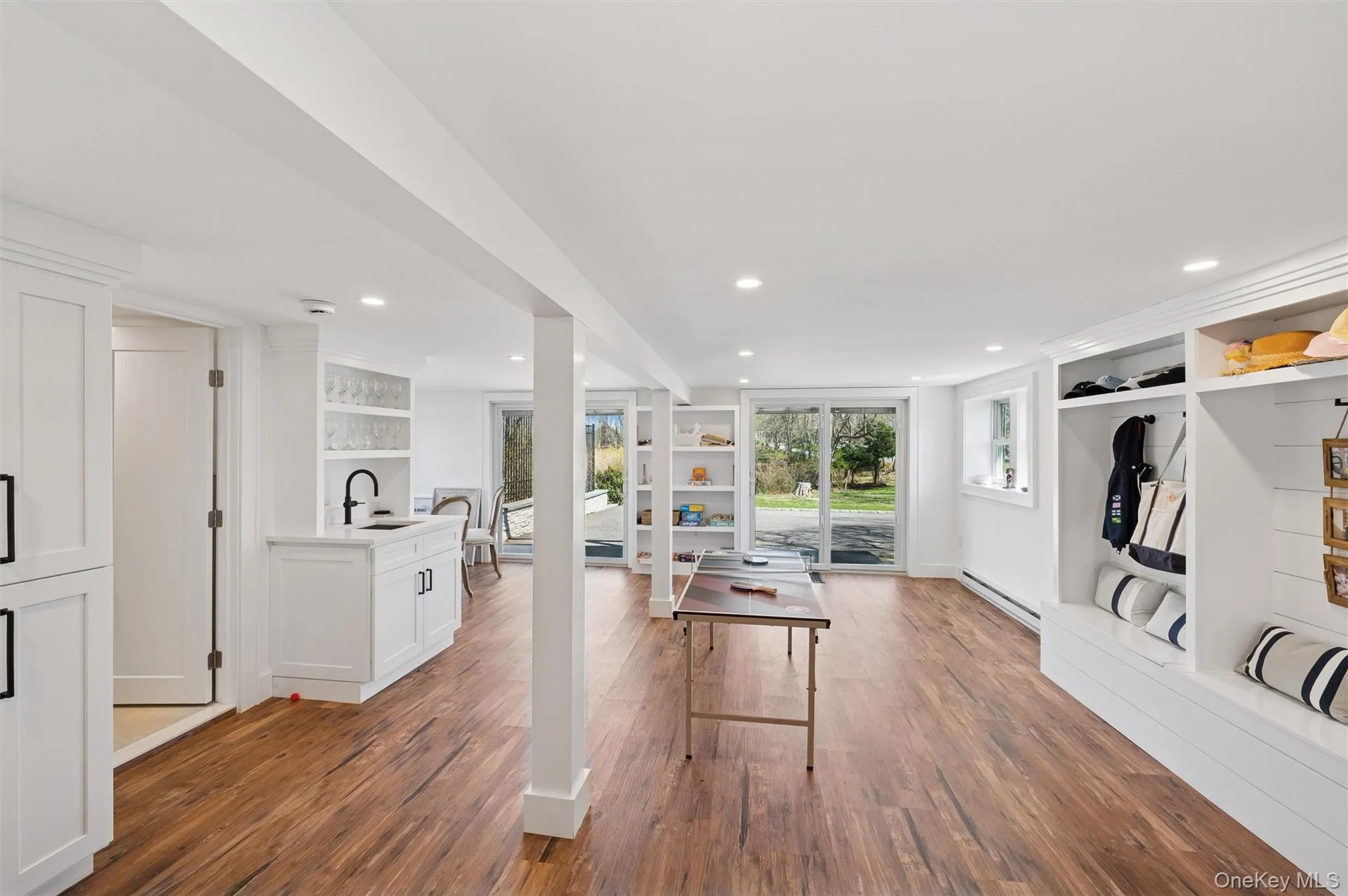 Workout room featuring recessed lighting, a baseboard heating unit, a sink, and wood finished floors Workout room featuring recessed lighting, a baseboard heating unit, a sink, and wood finished floors