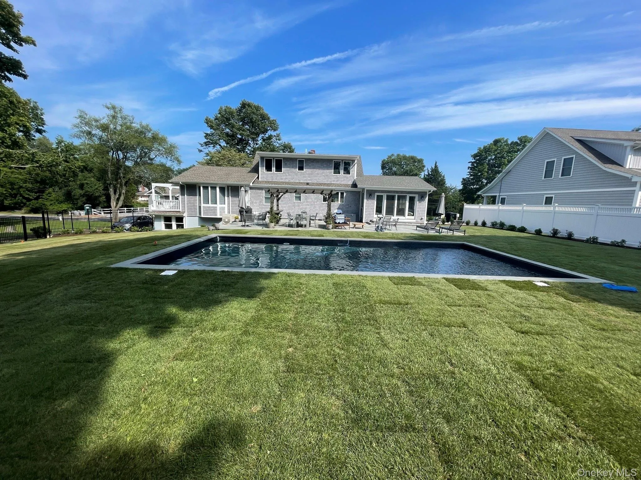 Rear view of house with a patio area, fence, a fenced in pool, and a lawn Rear view of house with a patio area, fence, a fenced in pool, and a lawn