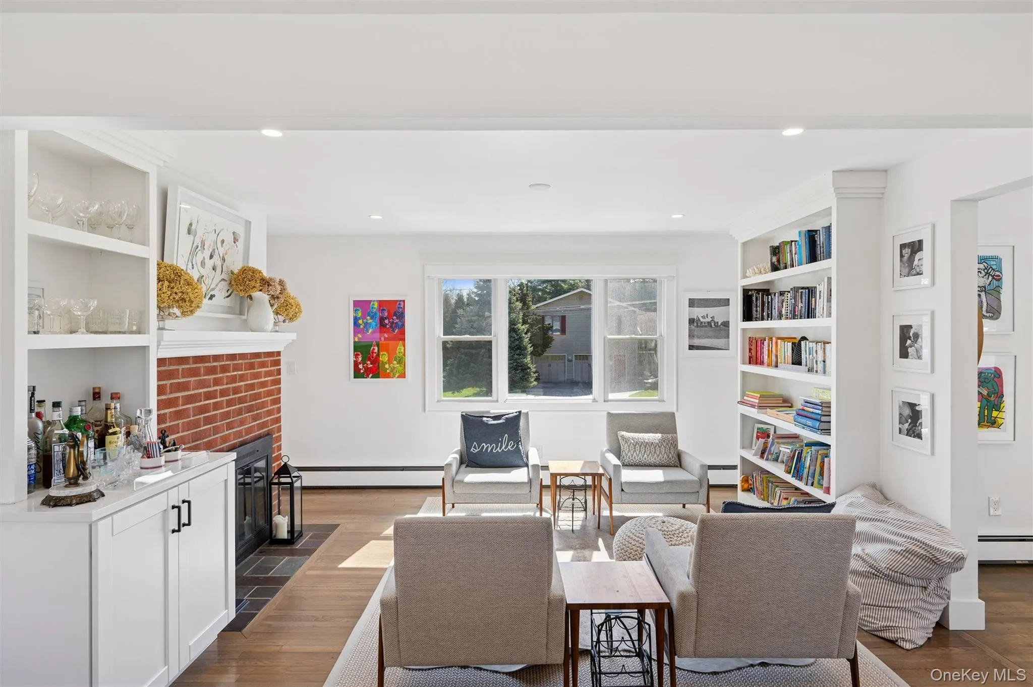 Living area featuring built in shelves, baseboard heating, a baseboard heating unit, and dark wood finished floors Living area featuring built in shelves, baseboard heating, a baseboard heating unit, and dark wood finished floors