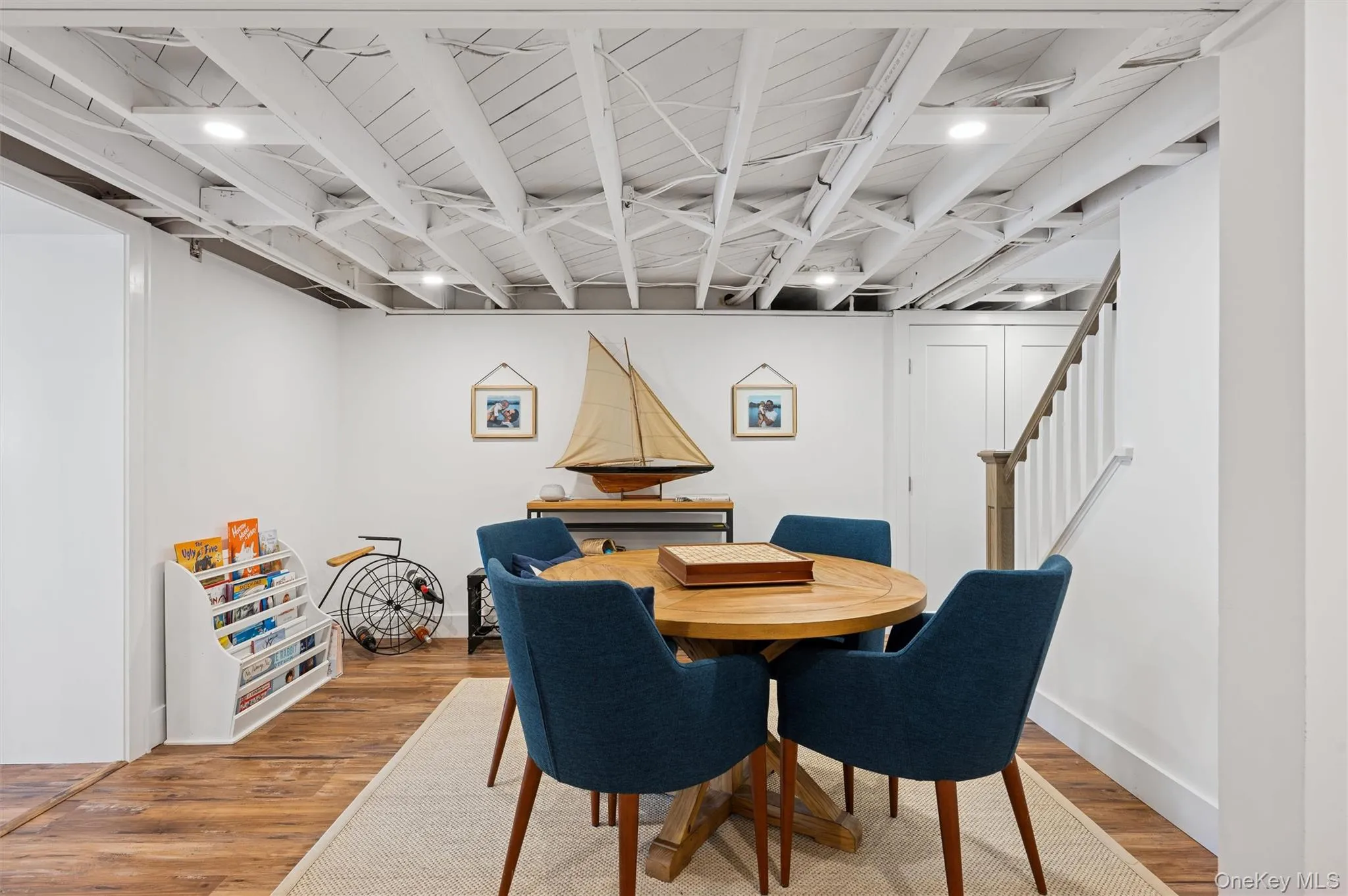 Dining space featuring light wood-style floors, baseboards, and stairs Dining space featuring light wood-style floors, baseboards, and stairs