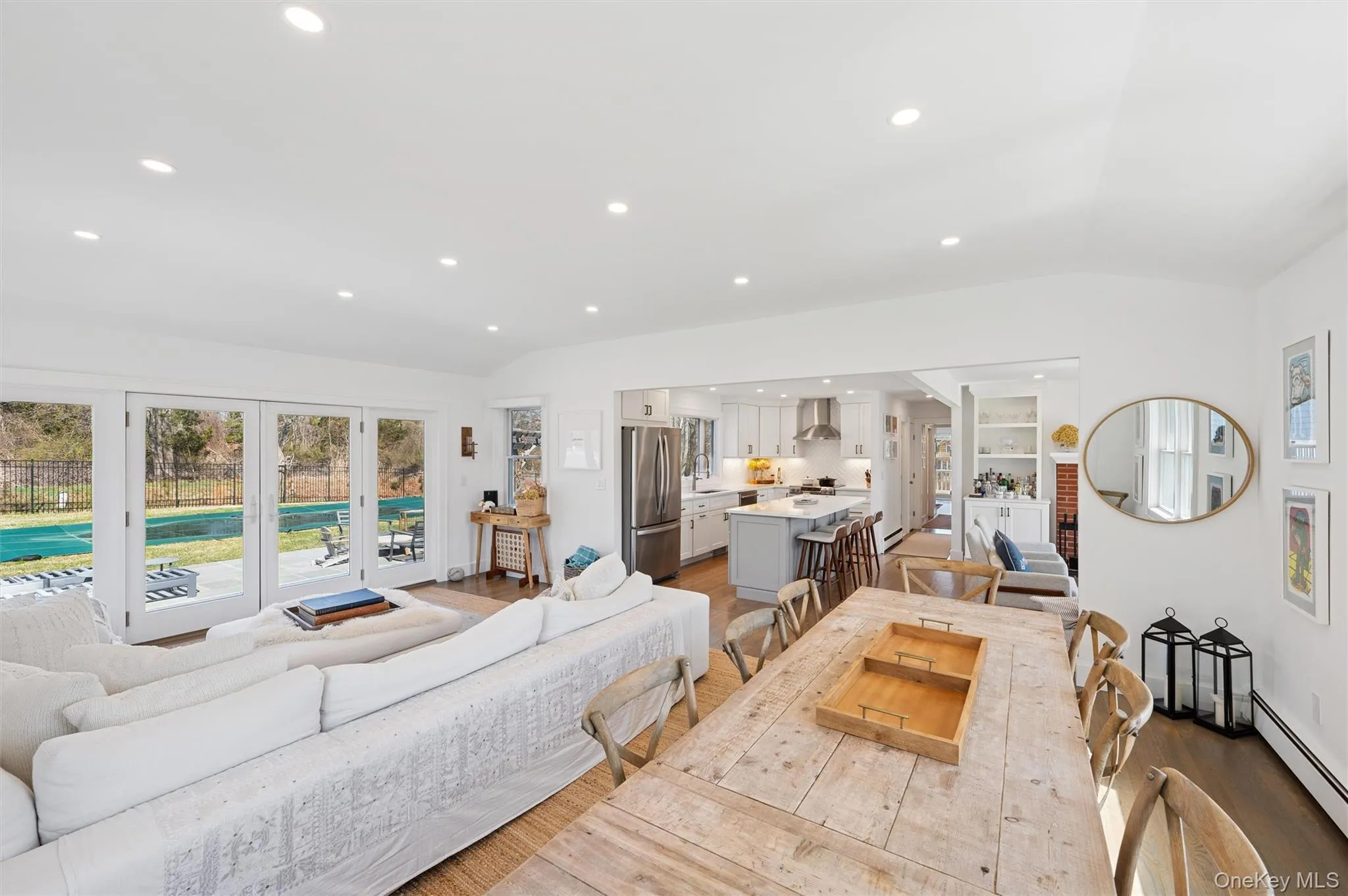 Living room featuring recessed lighting, a baseboard radiator, vaulted ceiling, and wood finished floors Living room featuring recessed lighting, a baseboard radiator, vaulted ceiling, and wood finished floors