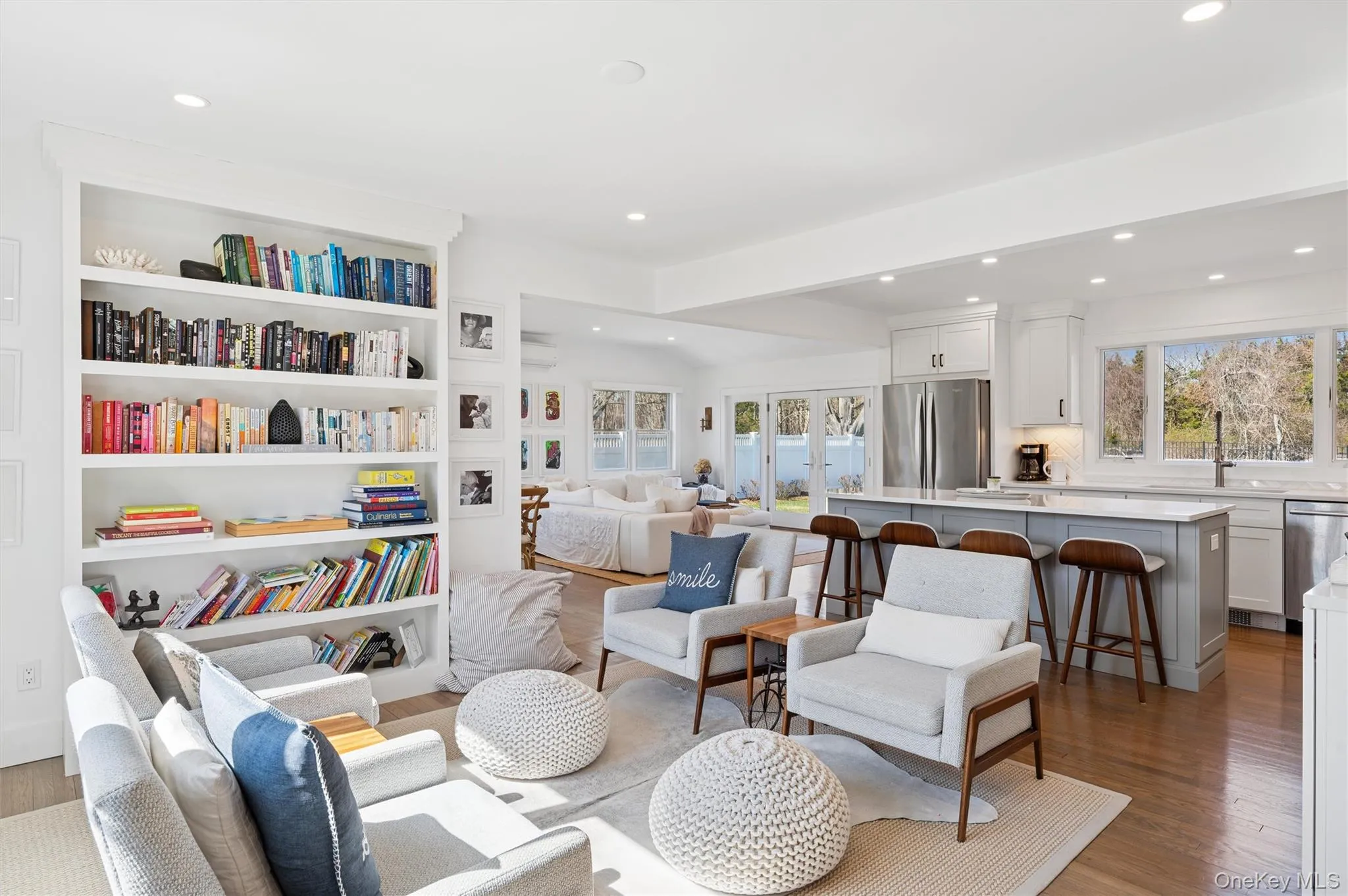 Living area featuring an AC wall unit, recessed lighting, and wood finished floors Living area featuring an AC wall unit, recessed lighting, and wood finished floors