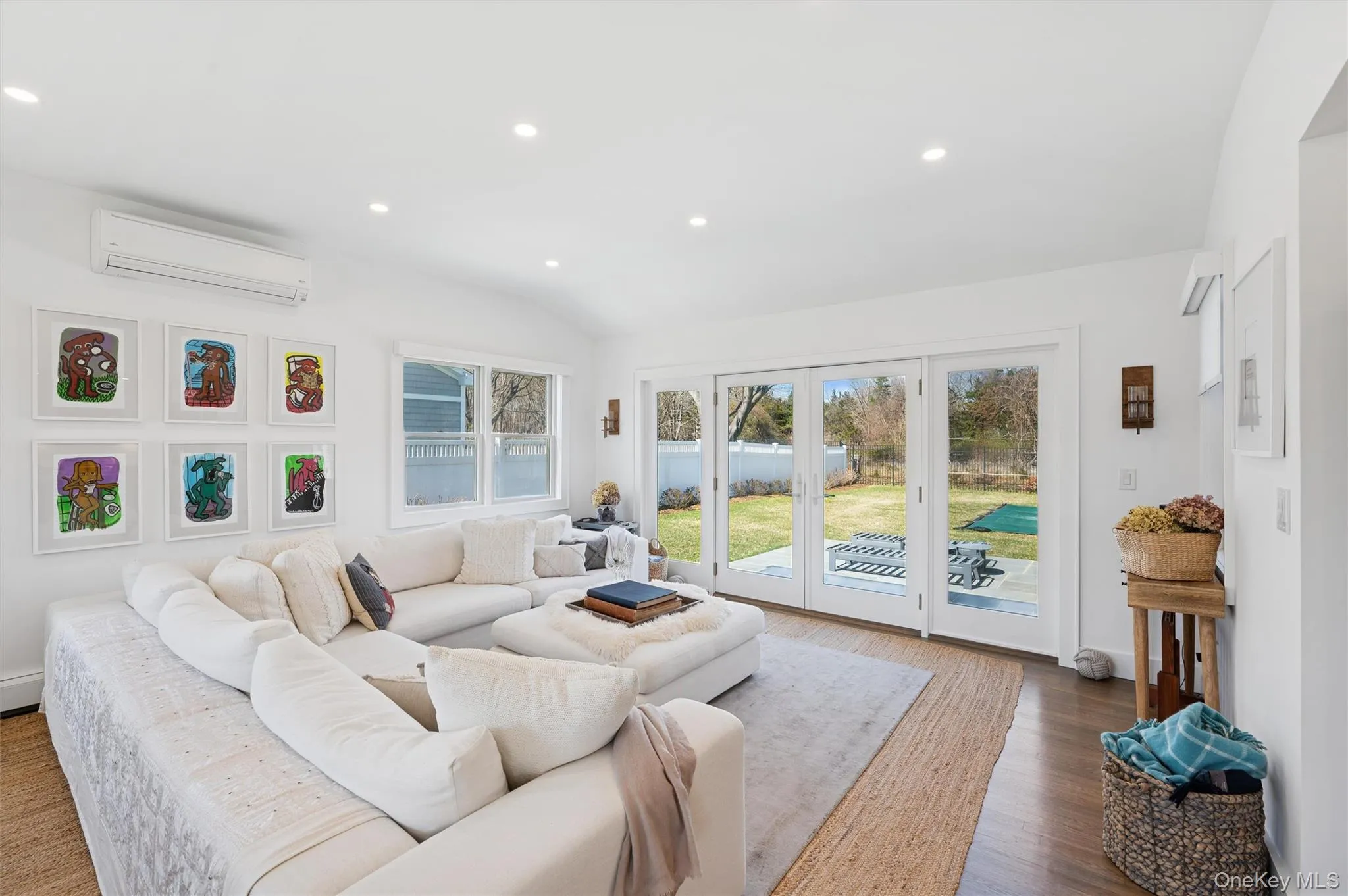 Living area with a wall mounted air conditioner, recessed lighting, dark wood-style floors, and vaulted ceiling Living area with a wall mounted air conditioner, recessed lighting, dark wood-style floors, and vaulted ceiling