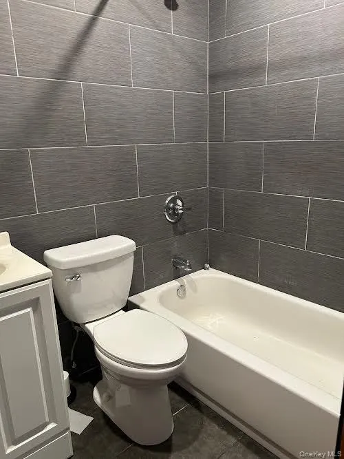 Full bath with tile walls, bathtub / shower combination, and vanity Full bath with tile walls, bathtub / shower combination, and vanity