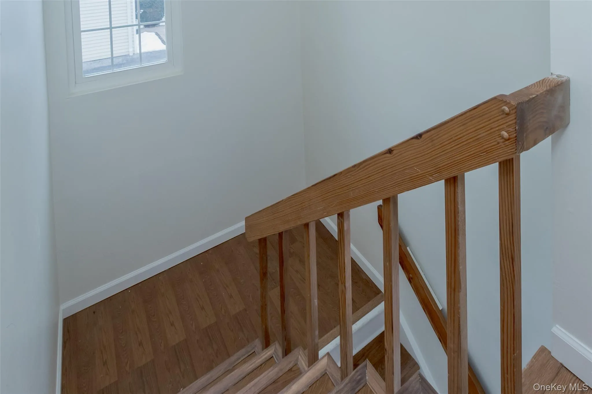Staircase with baseboards and wood finished floors Staircase with baseboards and wood finished floors