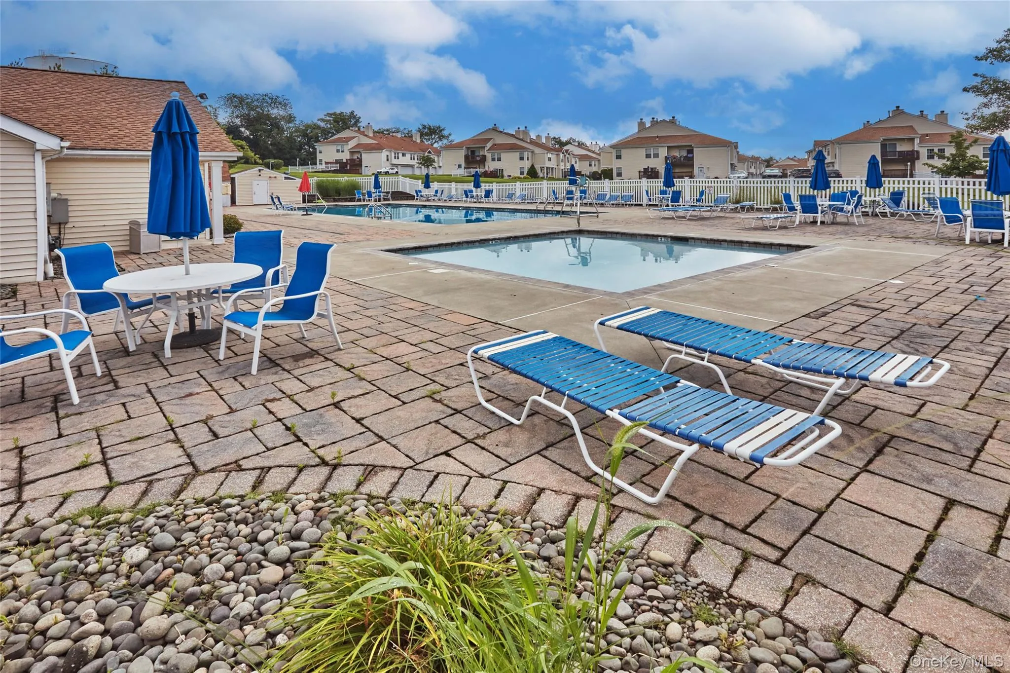 Community pool with a patio area and a residential view Community pool with a patio area and a residential view
