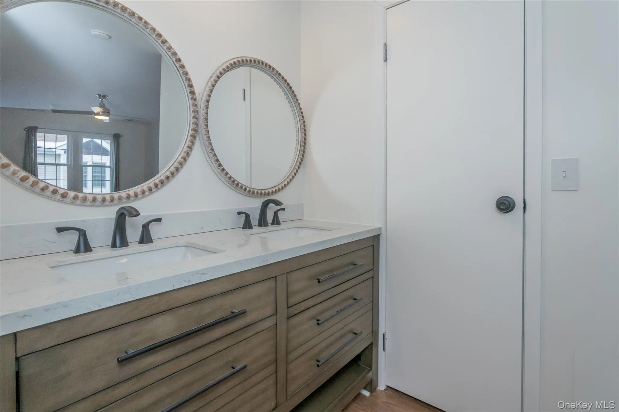Full bathroom featuring double vanity and a ceiling fan Full bathroom featuring double vanity and a ceiling fan