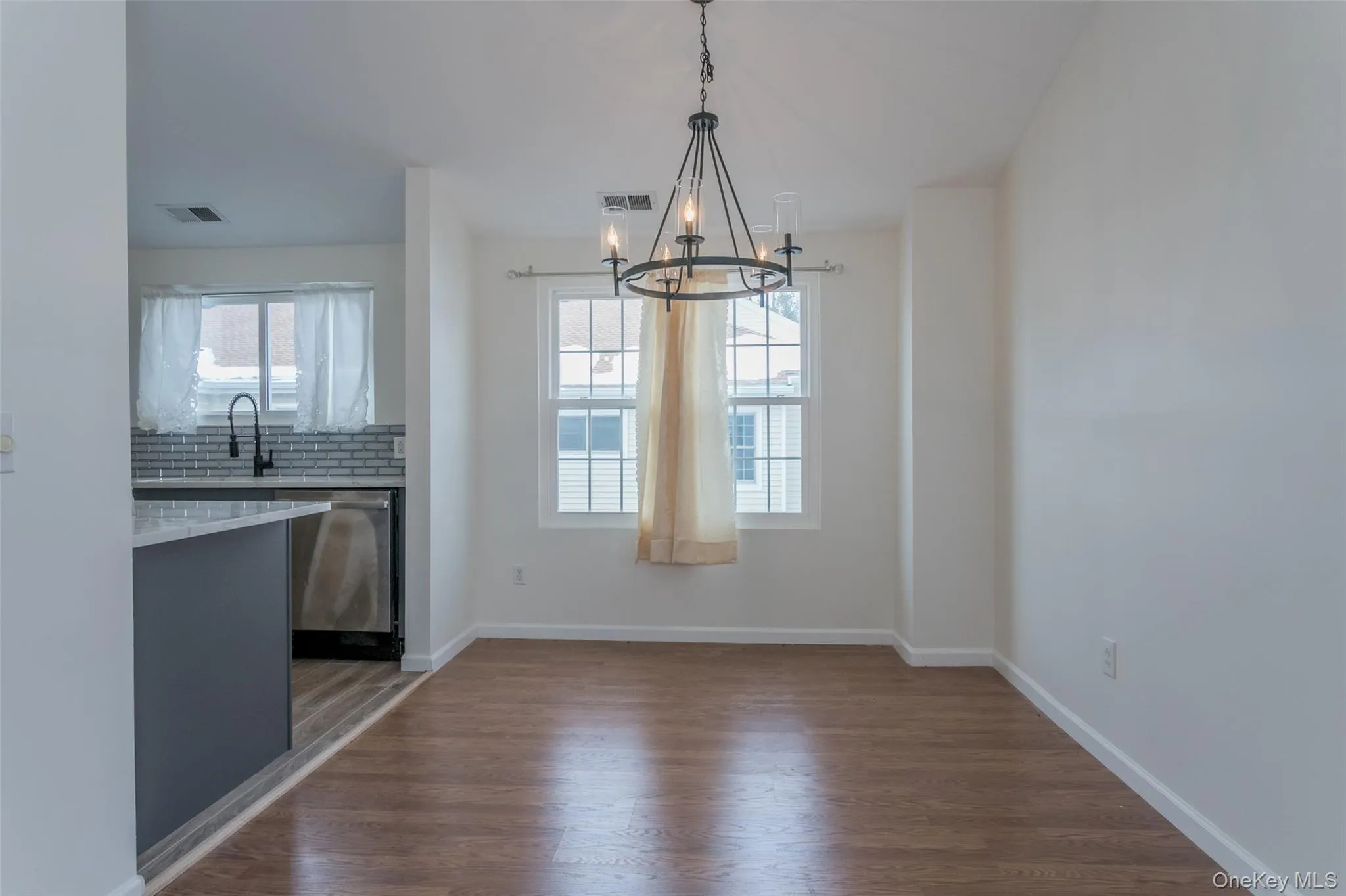 Unfurnished dining area featuring dark wood finished floors and a chandelier Unfurnished dining area featuring dark wood finished floors and a chandelier