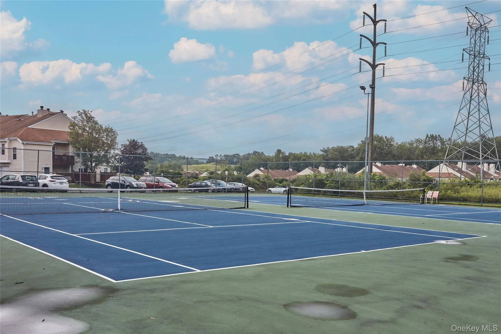 View of tennis court featuring community basketball court and a residential view View of tennis court featuring community basketball court and a residential view