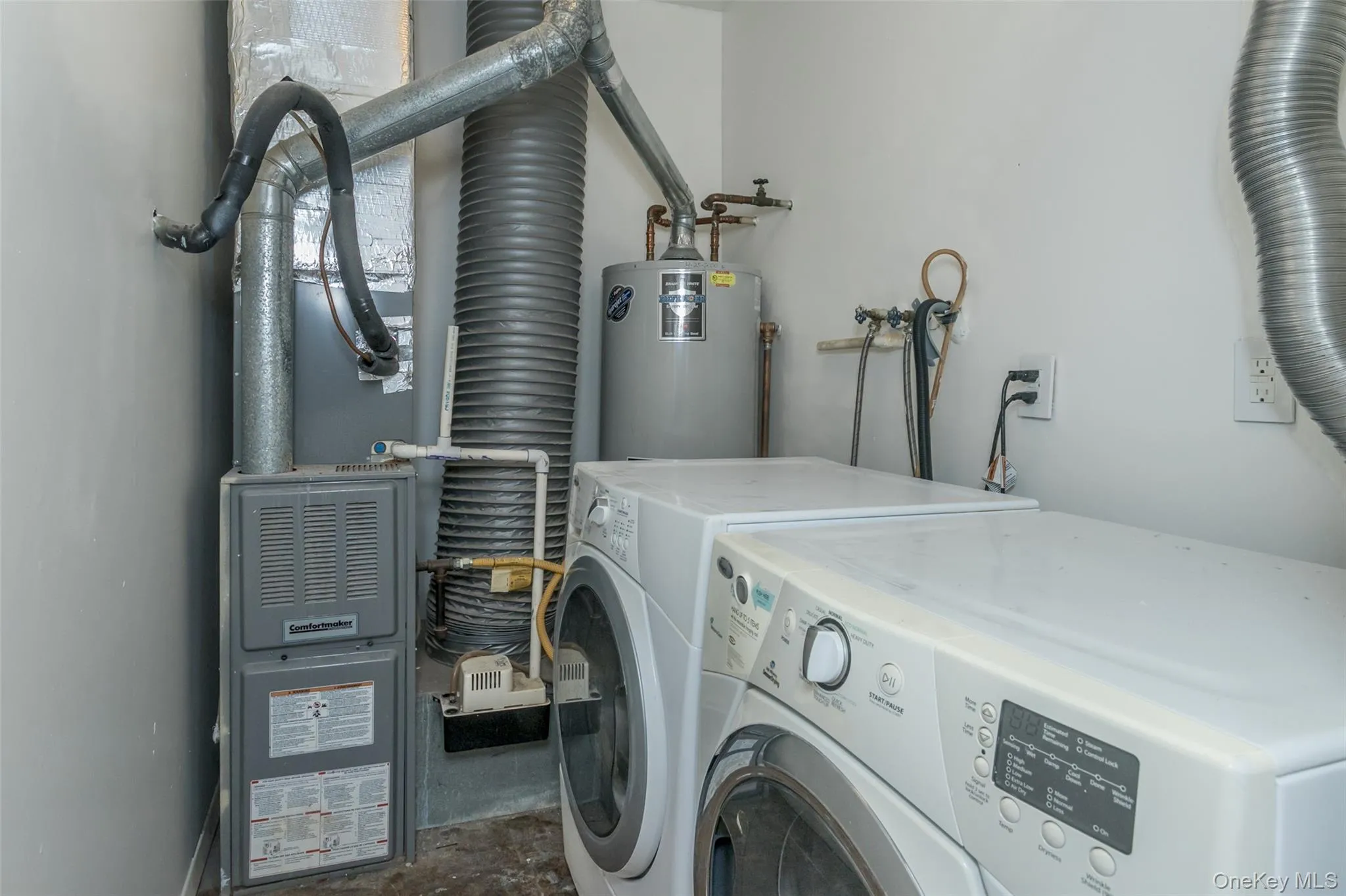 Laundry room featuring water heater, washer and clothes dryer, unfinished concrete flooring, and heating unit Laundry room featuring water heater, washer and clothes dryer, unfinished concrete flooring, and heating unit