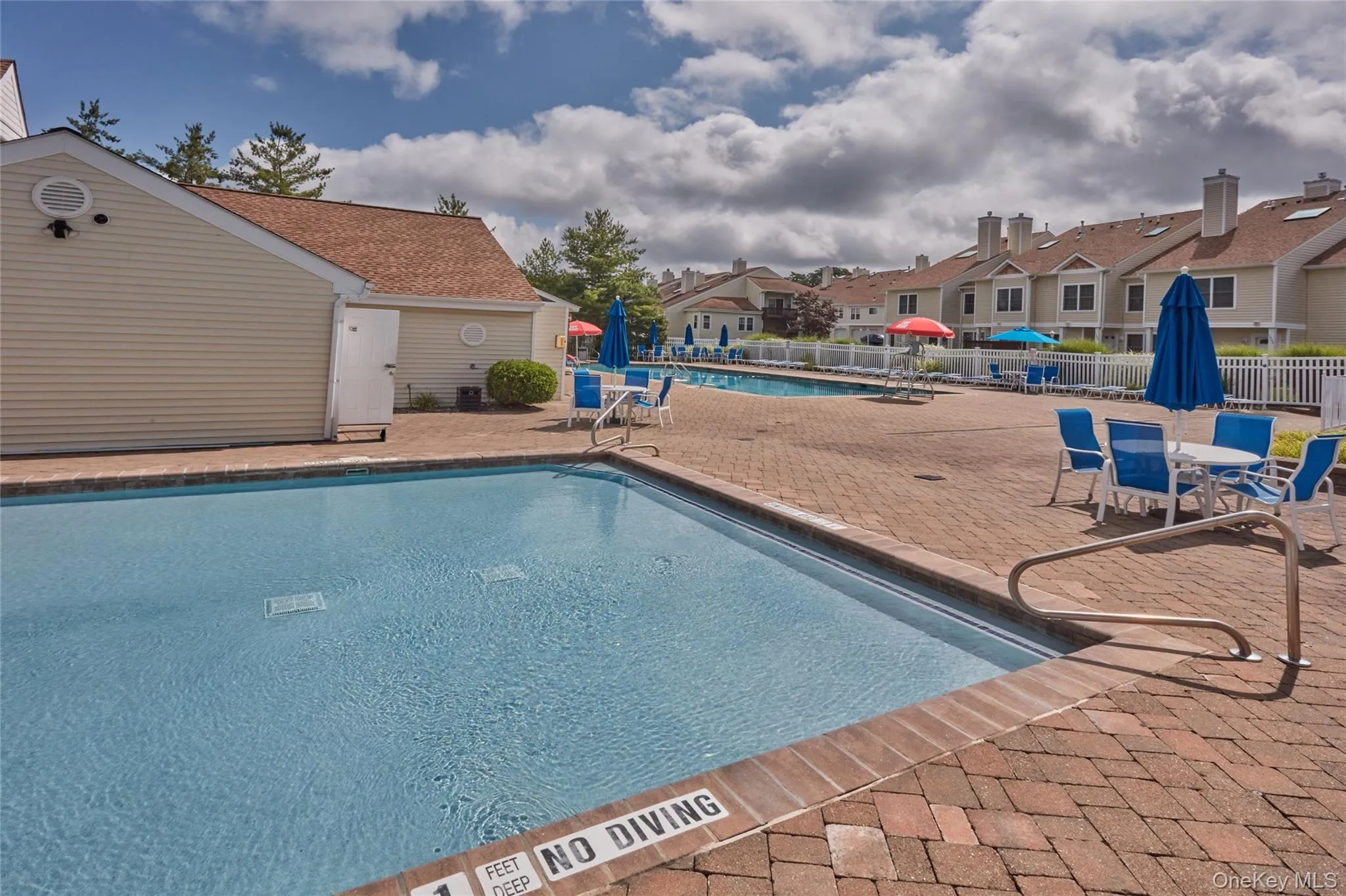 Community pool with a patio and a residential view Community pool with a patio and a residential view