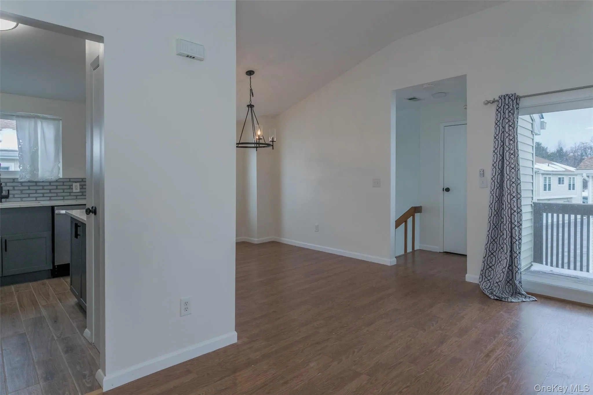 Unfurnished dining area with light wood finished floors, a chandelier, and vaulted ceiling Unfurnished dining area with light wood finished floors, a chandelier, and vaulted ceiling