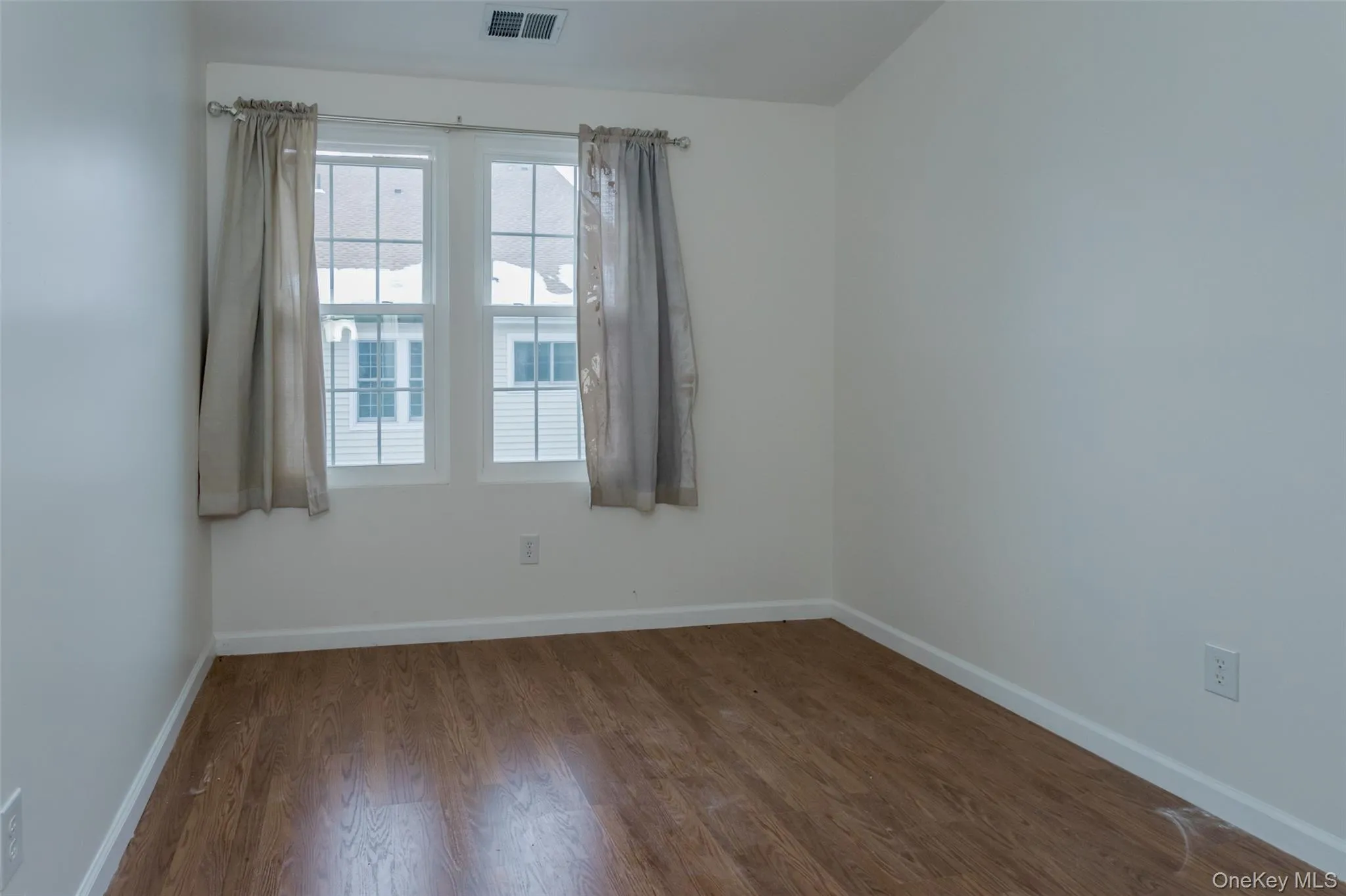Spare room with wood finished floors and baseboards Spare room with wood finished floors and baseboards