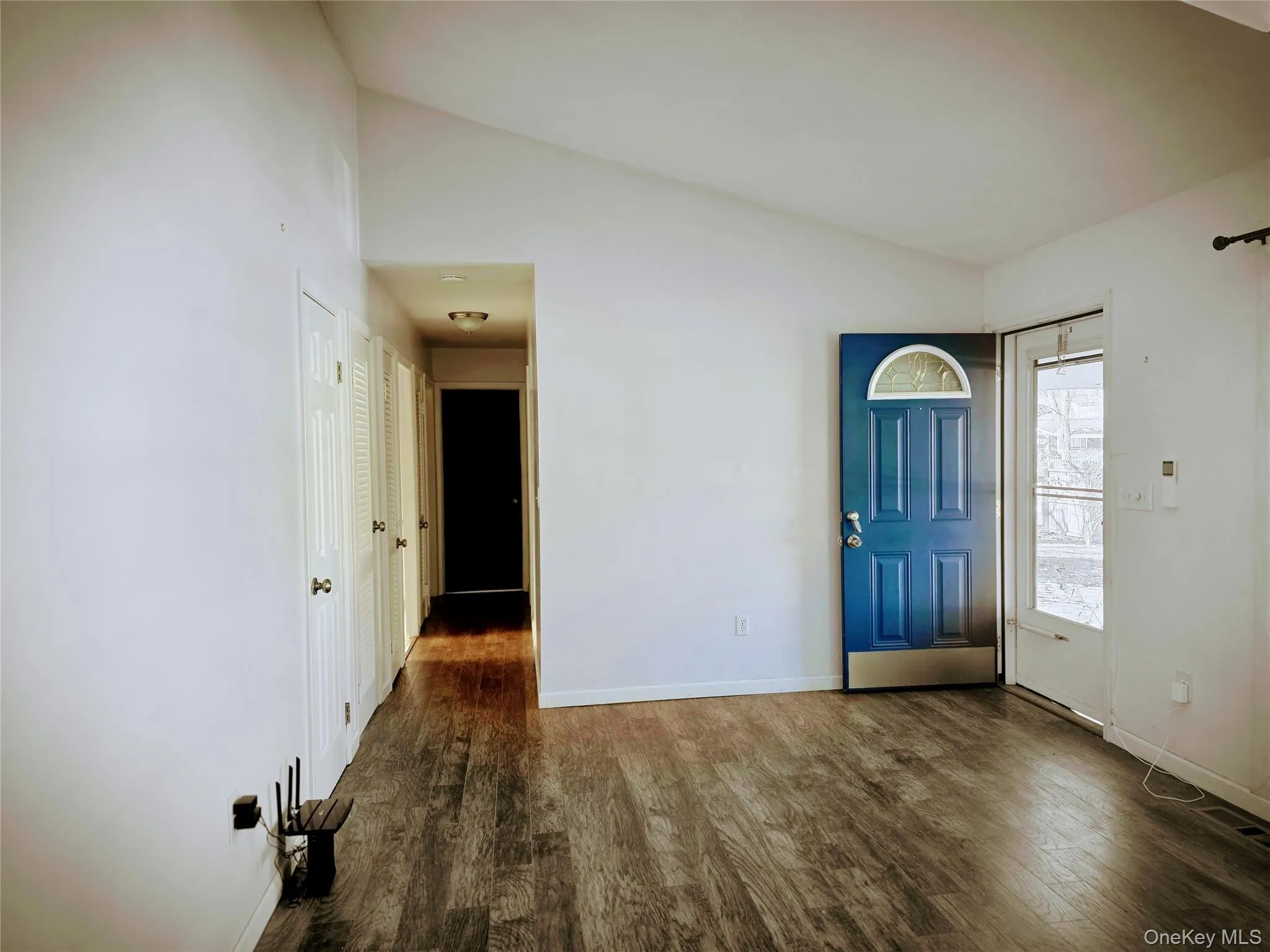 Foyer featuring vaulted ceiling and dark wood-style floors Foyer featuring vaulted ceiling and dark wood-style floors