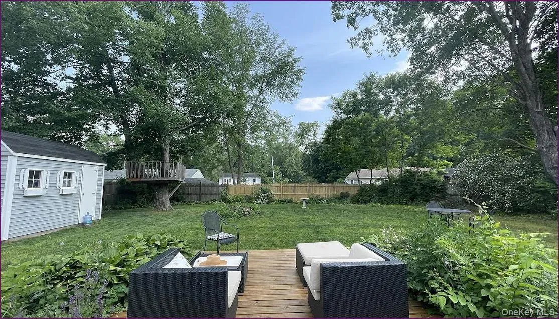 Fenced backyard featuring an outdoor hangout area, a shed, view of wooded area, and a deck Fenced backyard featuring an outdoor hangout area, a shed, view of wooded area, and a deck