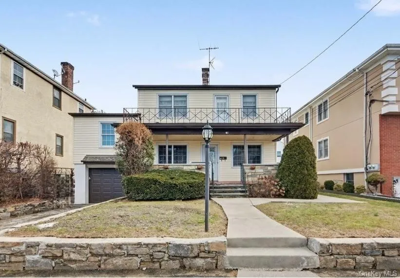 View of front of property featuring a porch, an attached garage, and a front lawn View of front of property featuring a porch, an attached garage, and a front lawn