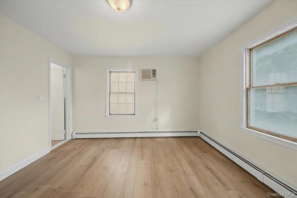 Spare room with a baseboard heating unit and light wood-type flooring Spare room with a baseboard heating unit and light wood-type flooring