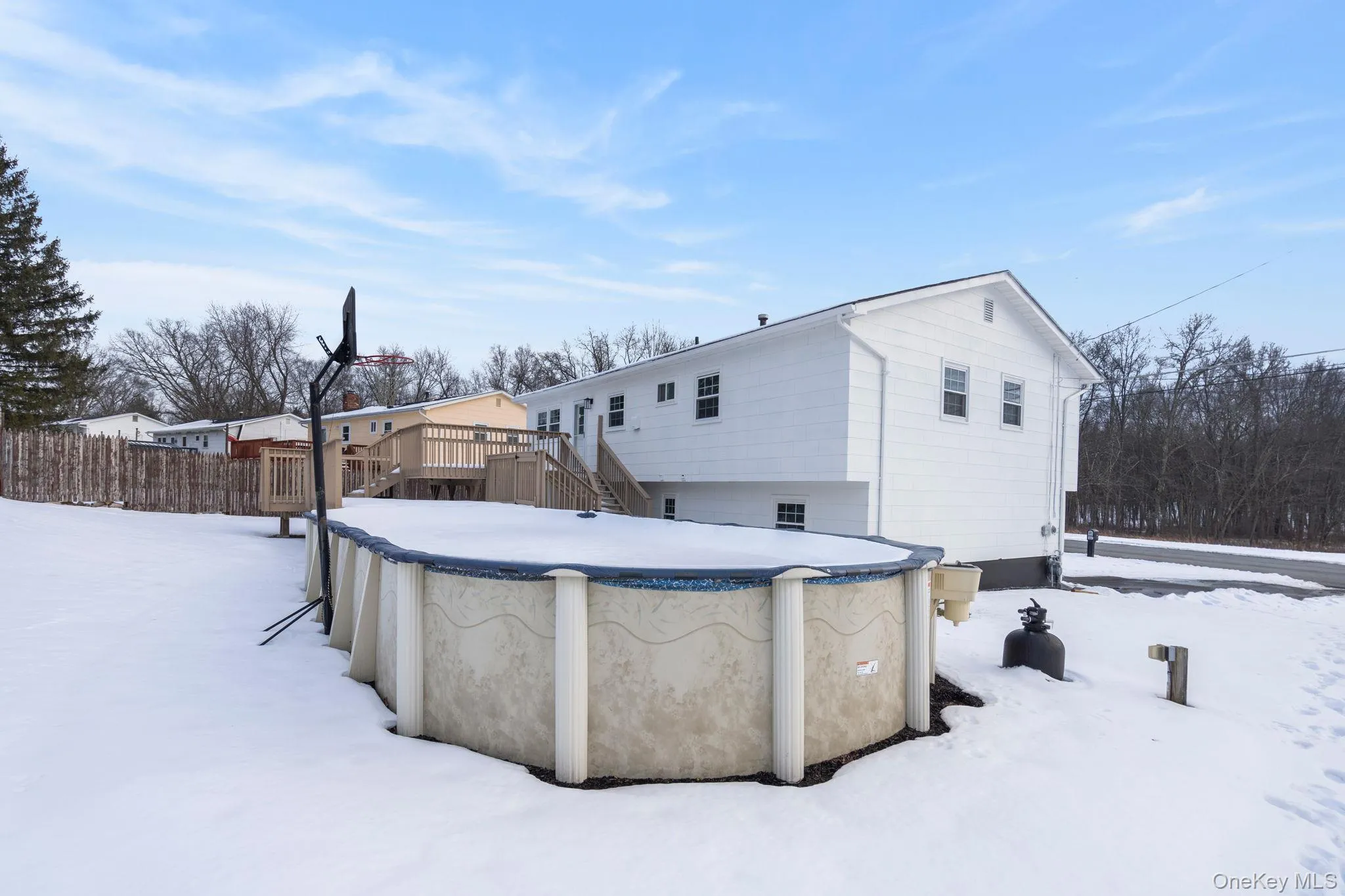 Snow covered back of property with a covered pool, stairway, and a deck Snow covered back of property with a covered pool, stairway, and a deck