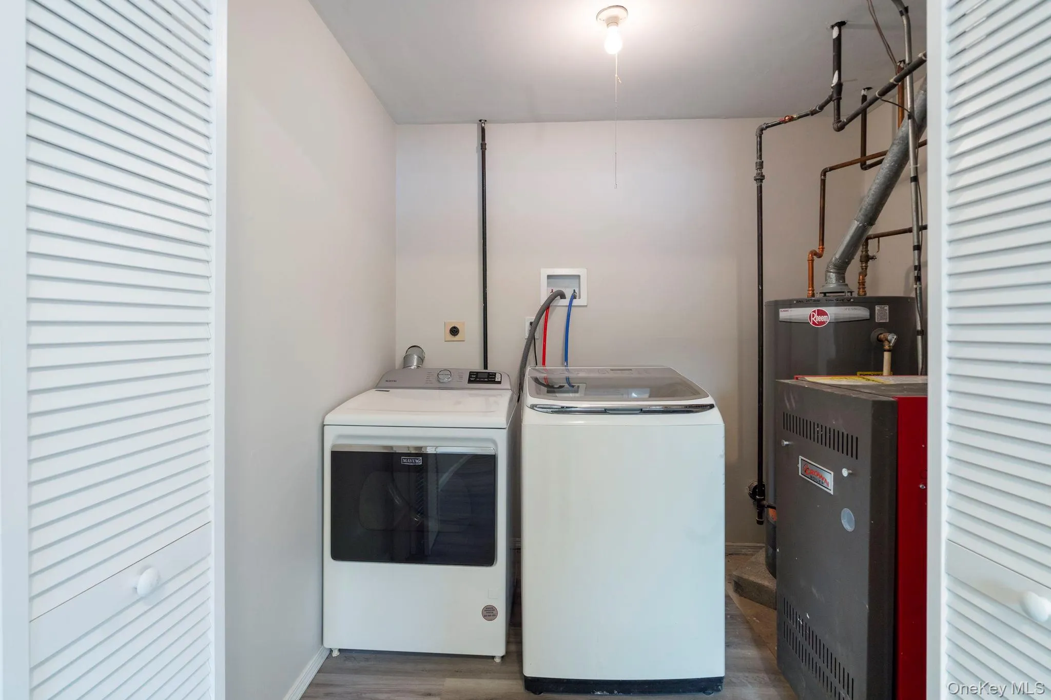Laundry room with washing machine and dryer, dark wood-type flooring, a heating unit, and gas water heater Laundry room with washing machine and dryer, dark wood-type flooring, a heating unit, and gas water heater