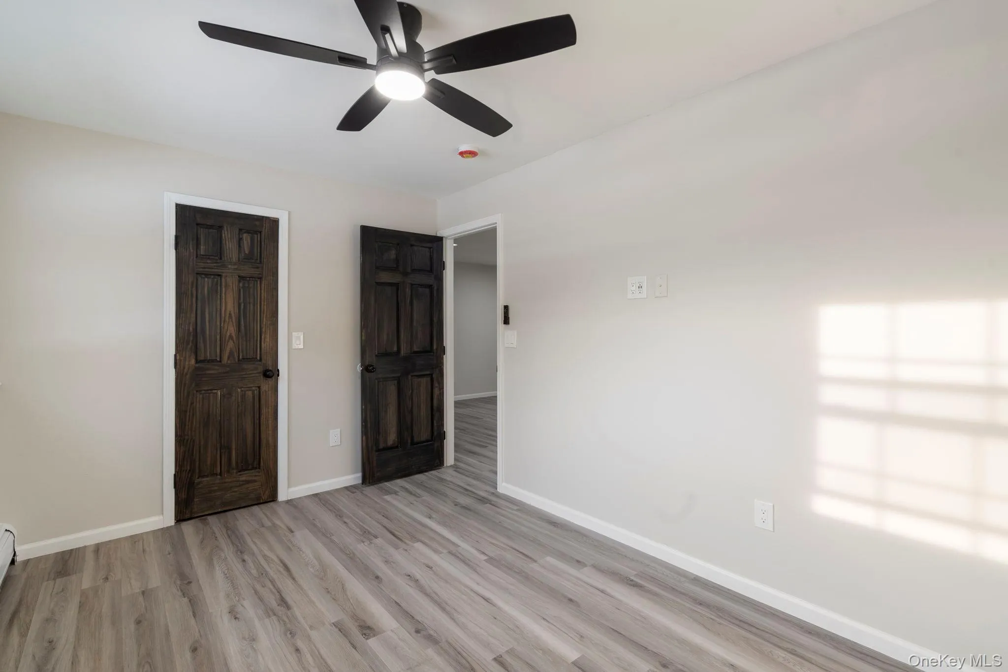 Unfurnished bedroom featuring light wood-type flooring and a ceiling fan Unfurnished bedroom featuring light wood-type flooring and a ceiling fan