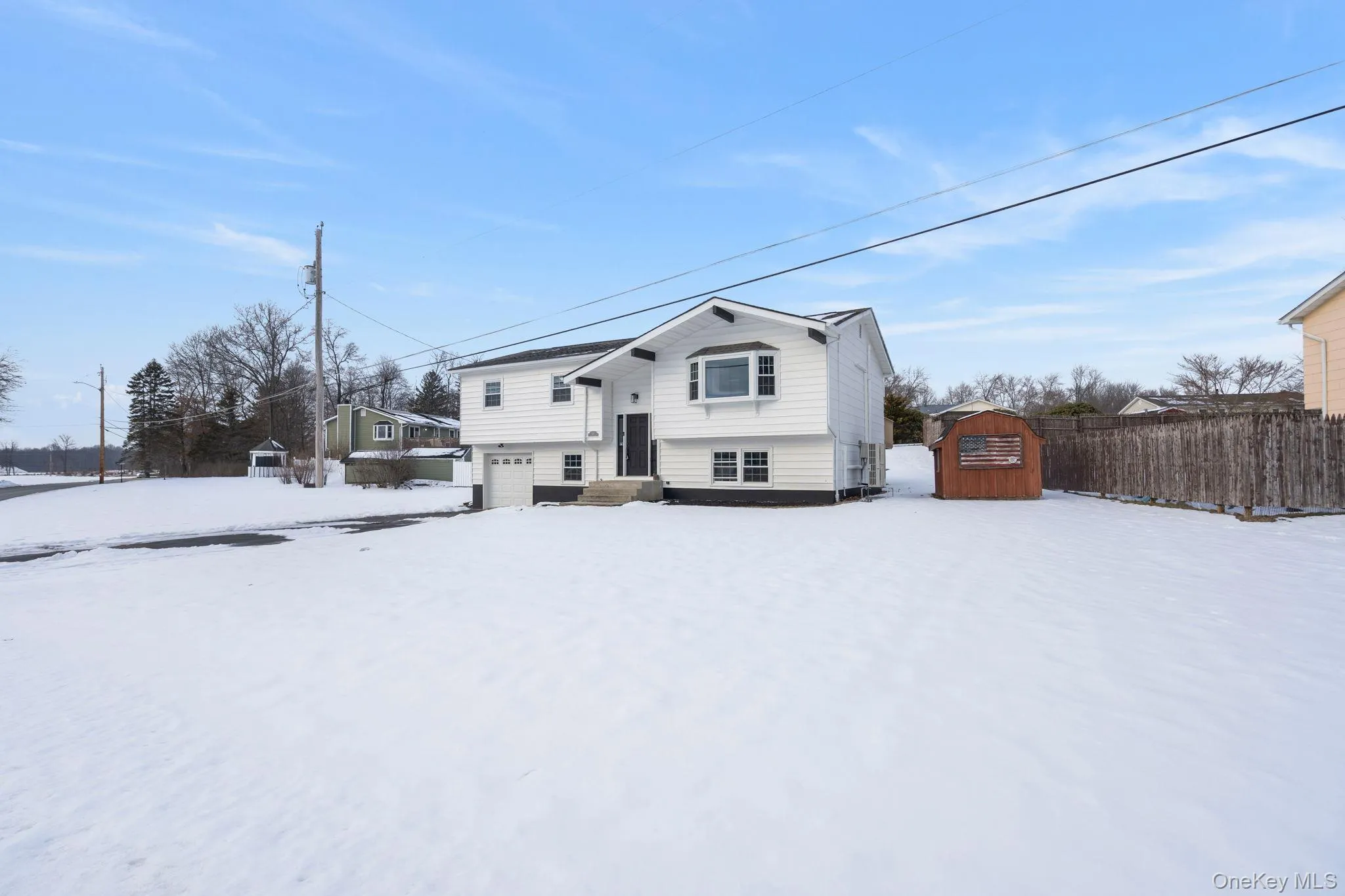 Snow covered back of property featuring a shed Snow covered back of property featuring a shed