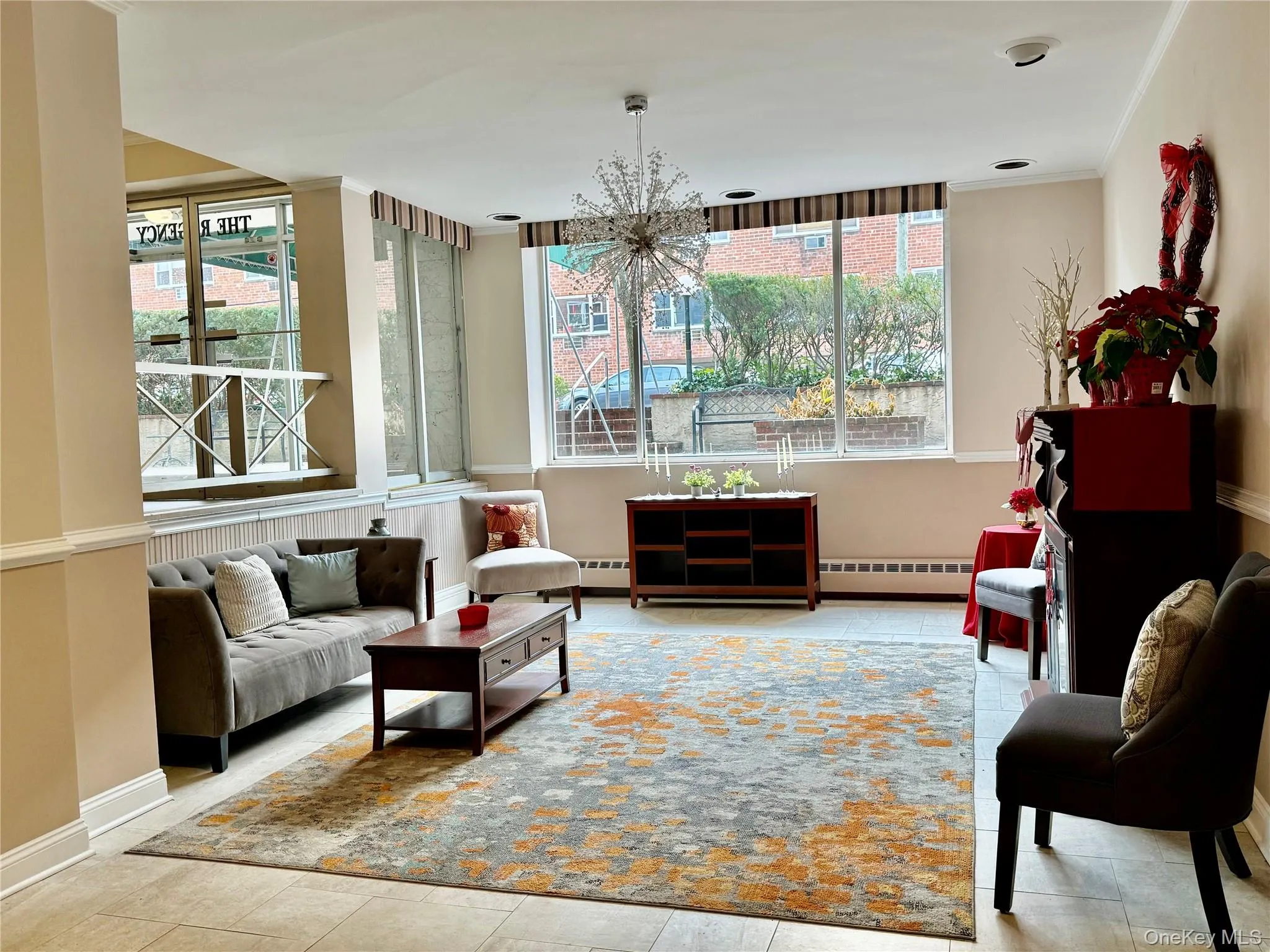 Sitting room with ornamental molding, baseboard heating, and a chandelier Sitting room with ornamental molding, baseboard heating, and a chandelier