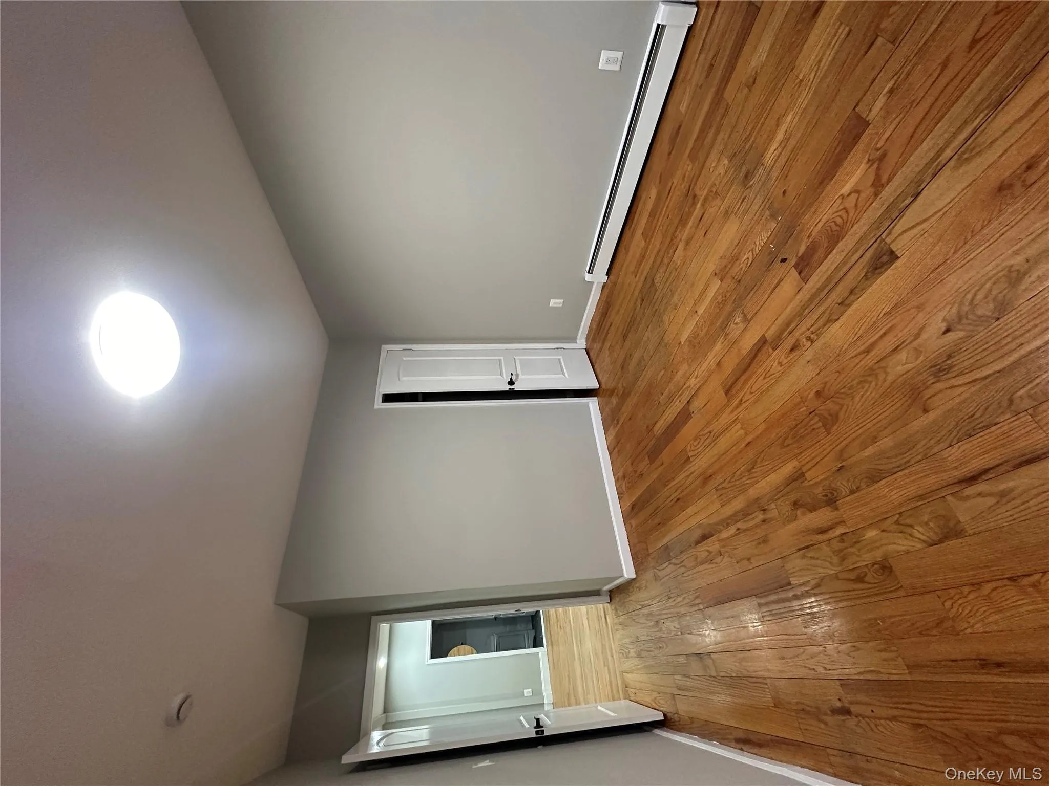 Unfurnished room featuring a baseboard heating unit and hardwood / wood-style flooring Unfurnished room featuring a baseboard heating unit and hardwood / wood-style flooring