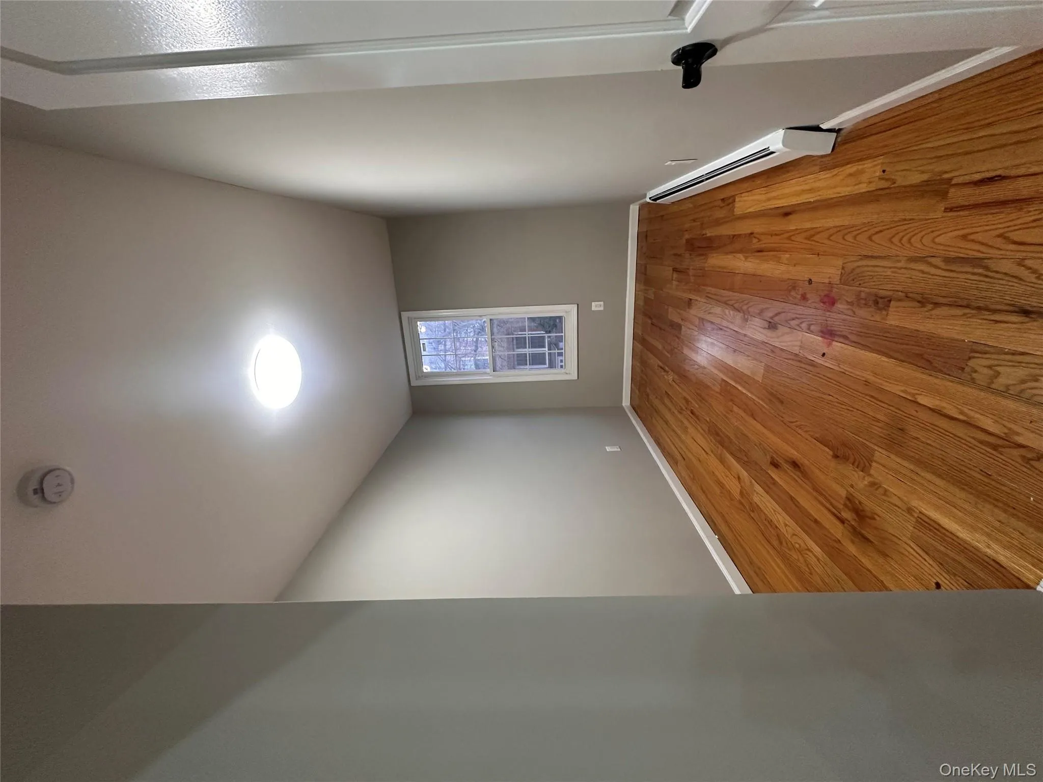 Empty room with a baseboard radiator and light wood finished floors Empty room with a baseboard radiator and light wood finished floors