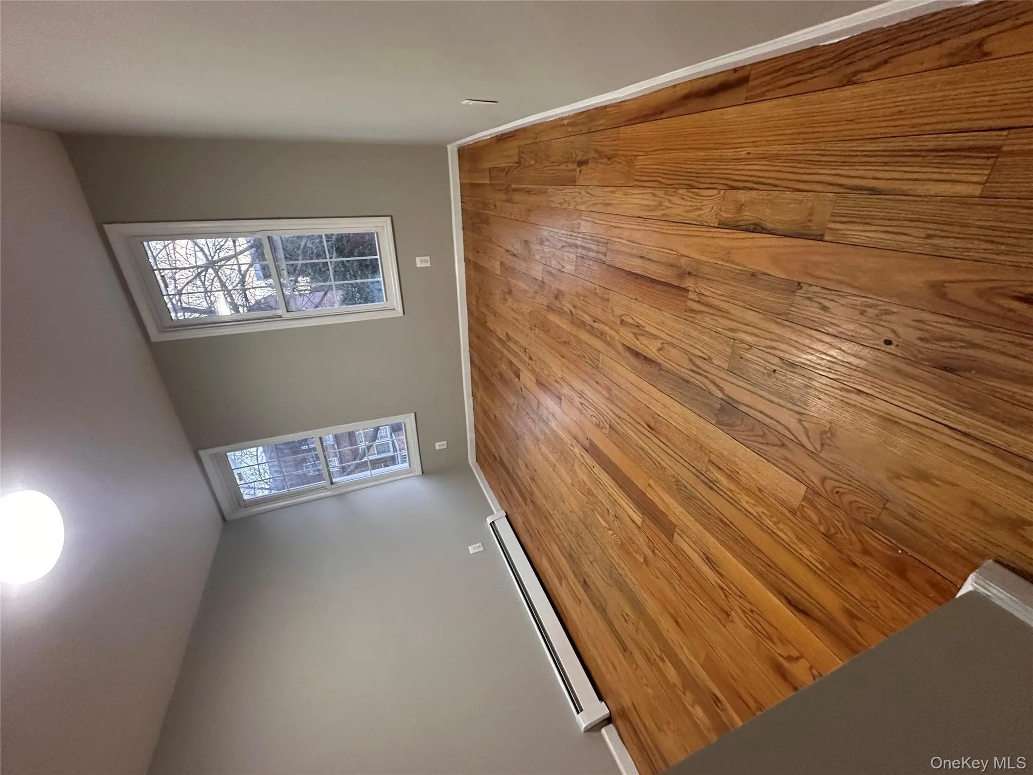Spare room featuring baseboard heating and light wood-style floors Spare room featuring baseboard heating and light wood-style floors